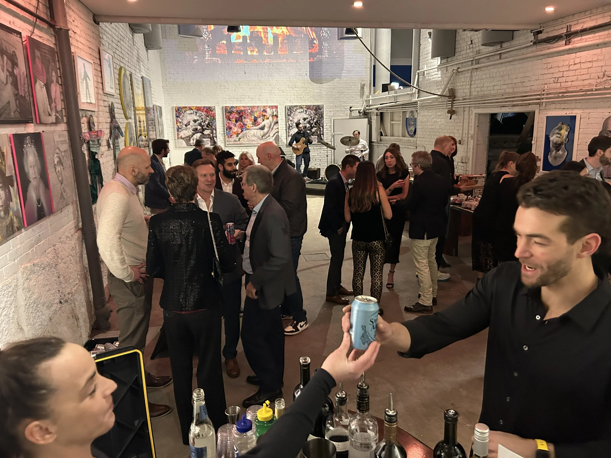 Bartender serving a guest during a HOST Events corporate event while attendees mingle and connect throughout the venue, illustrating how personal interactions help shape lasting impressions.