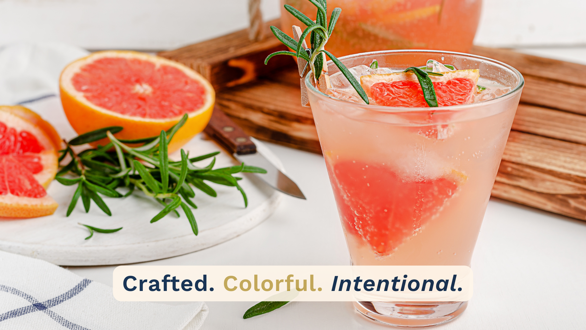 Close-up editorial-style mocktail featuring grapefruit, rosemary garnish, sparkling citrus beverage, and fresh ingredients styled on a bright tabletop. Overlay text reads: “Crafted. Colorful. Intentional.” in HOST brand colors and typography.