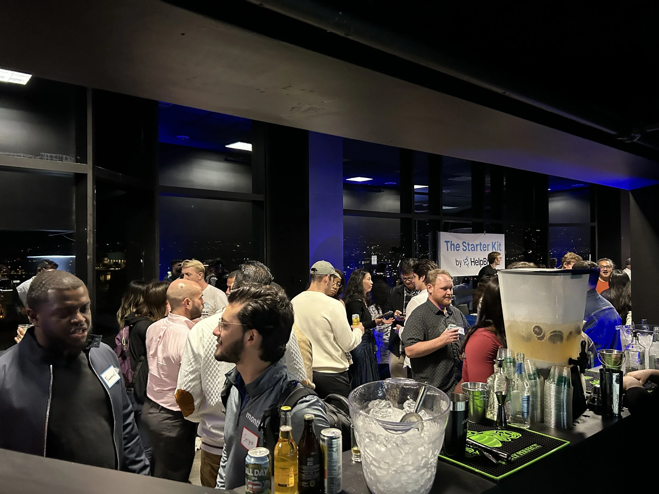 Guests gather during a HOST Events networking and hospitality experience featuring drinks, conversation, and city views during an evening corporate event.