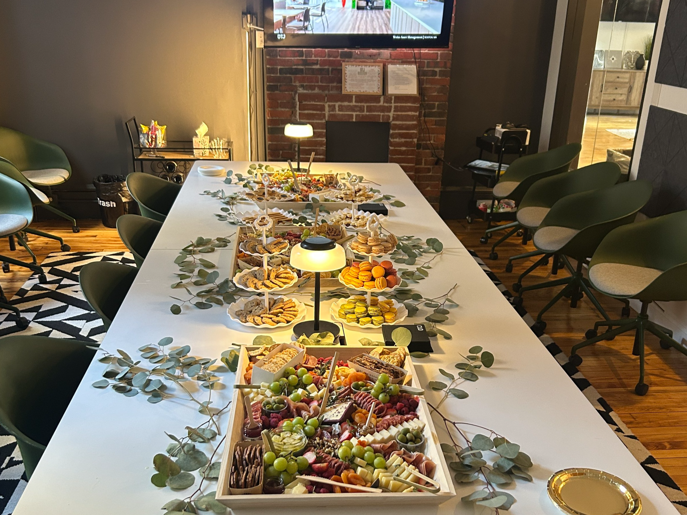 Grazing table displayed in conference room with charcuterie boards, savory and sweet light bites