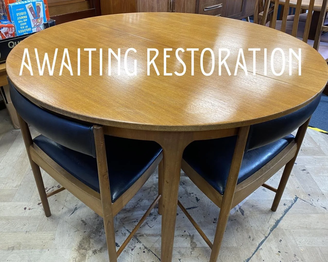 1960s McIntosh circular teak extending dining table and four black vinyl chairs