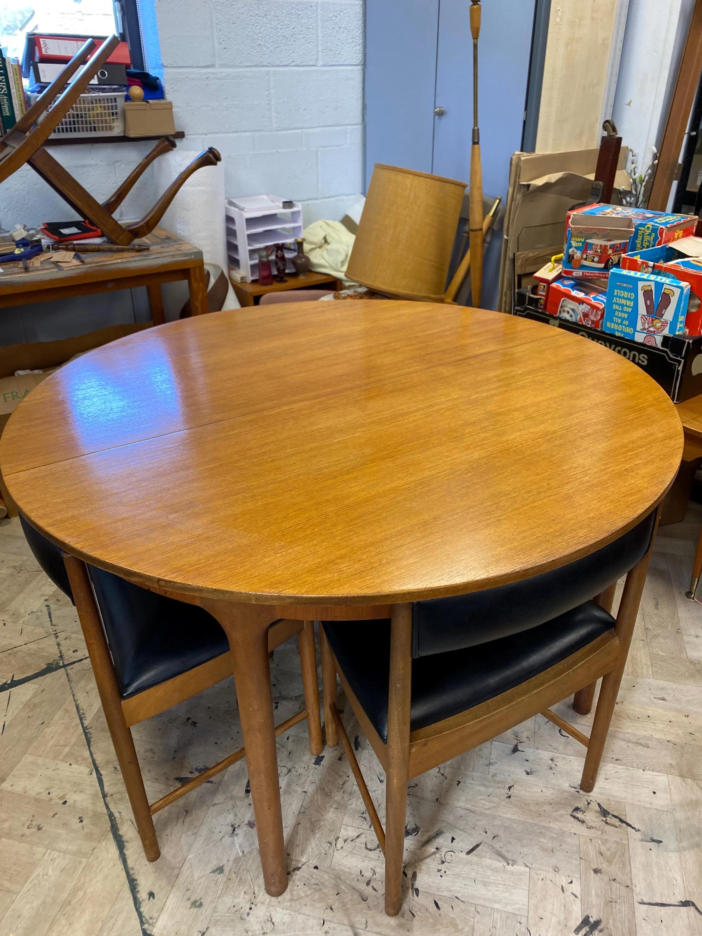 1960s McIntosh circular teak extending dining table and four black vinyl chairs