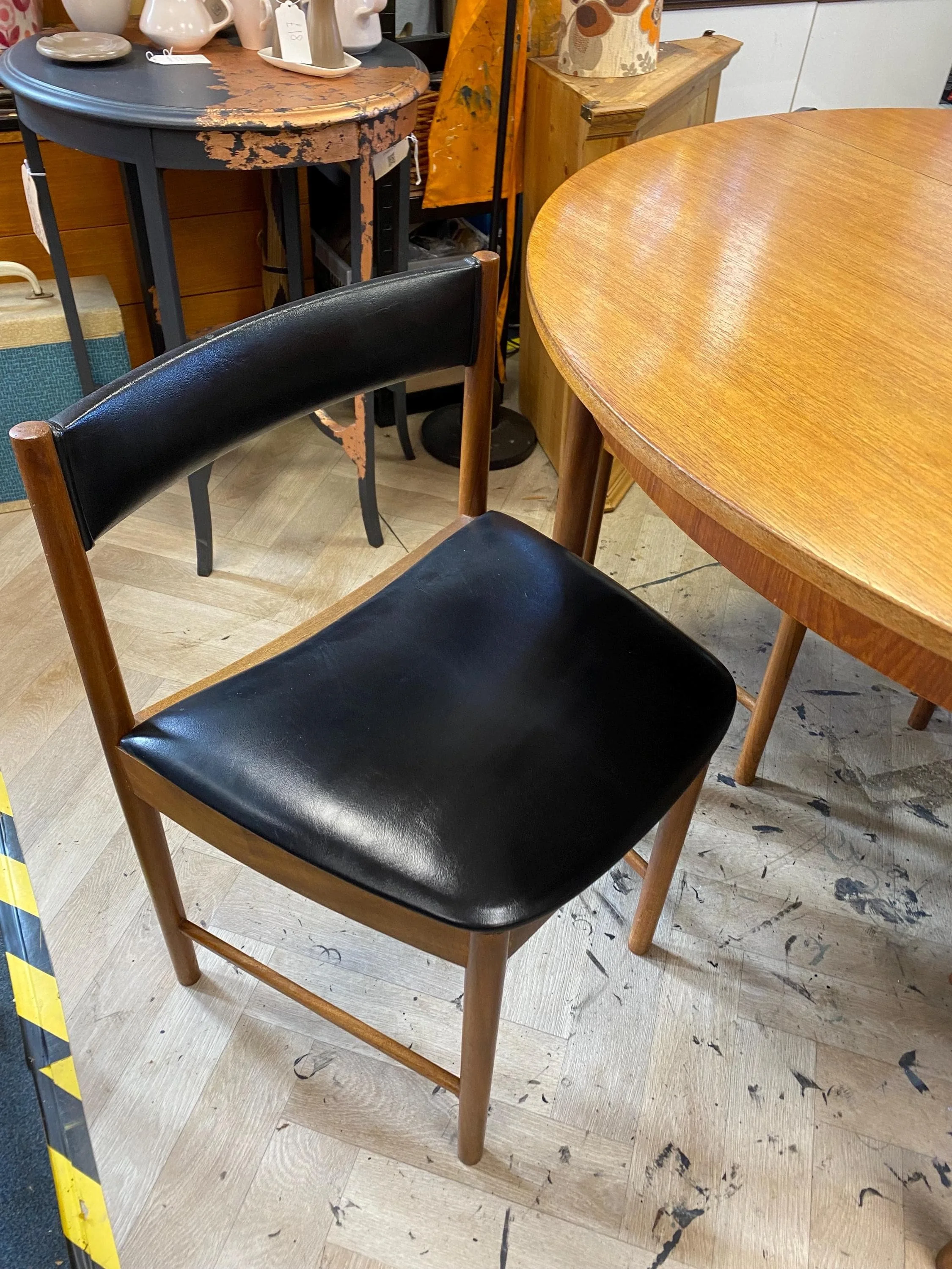 1960s McIntosh circular teak extending dining table and four black vinyl chairs