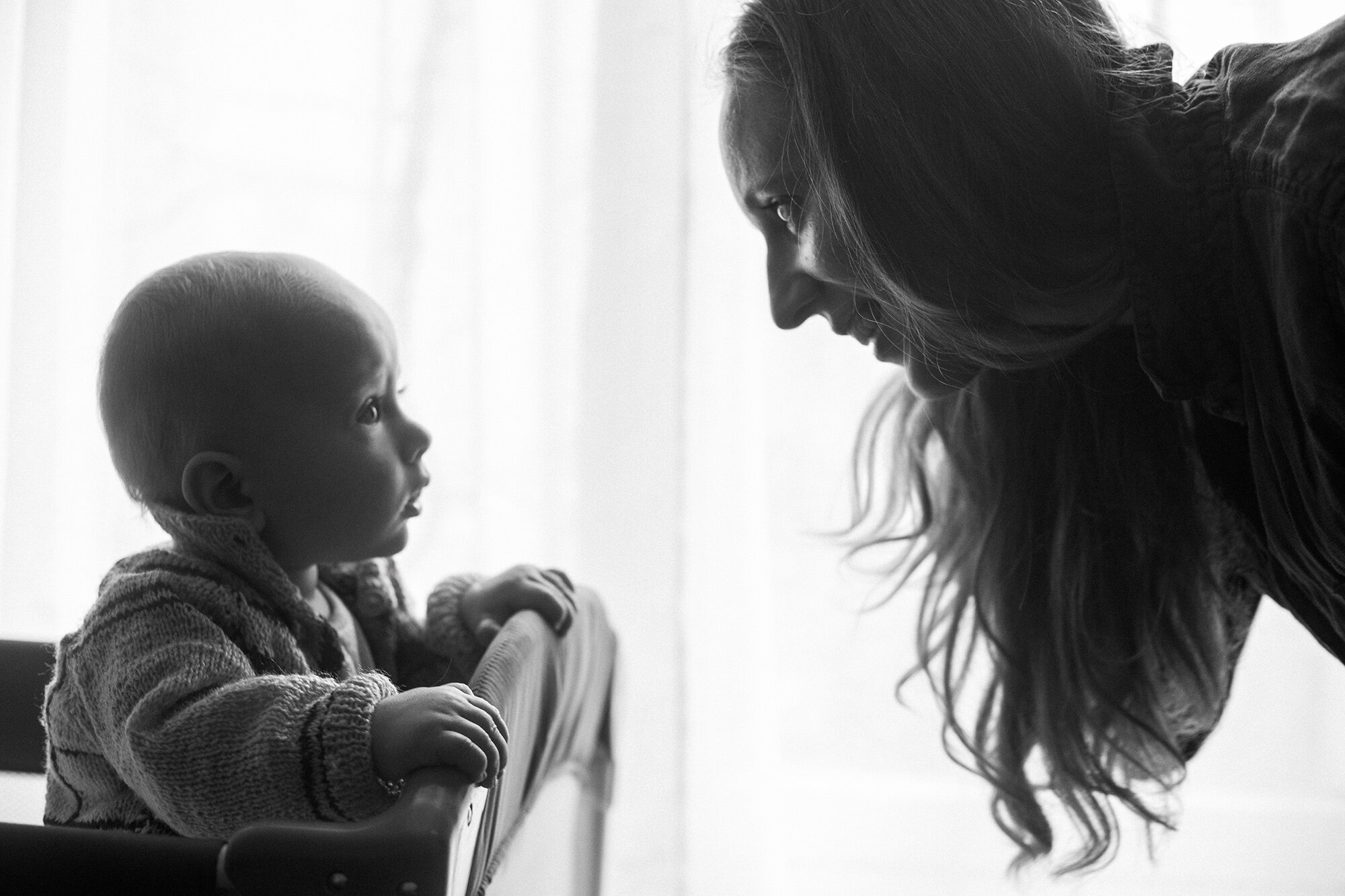Baby boy looking at his smiling mother