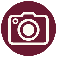 A white camera icon on a dark maroon circular background.