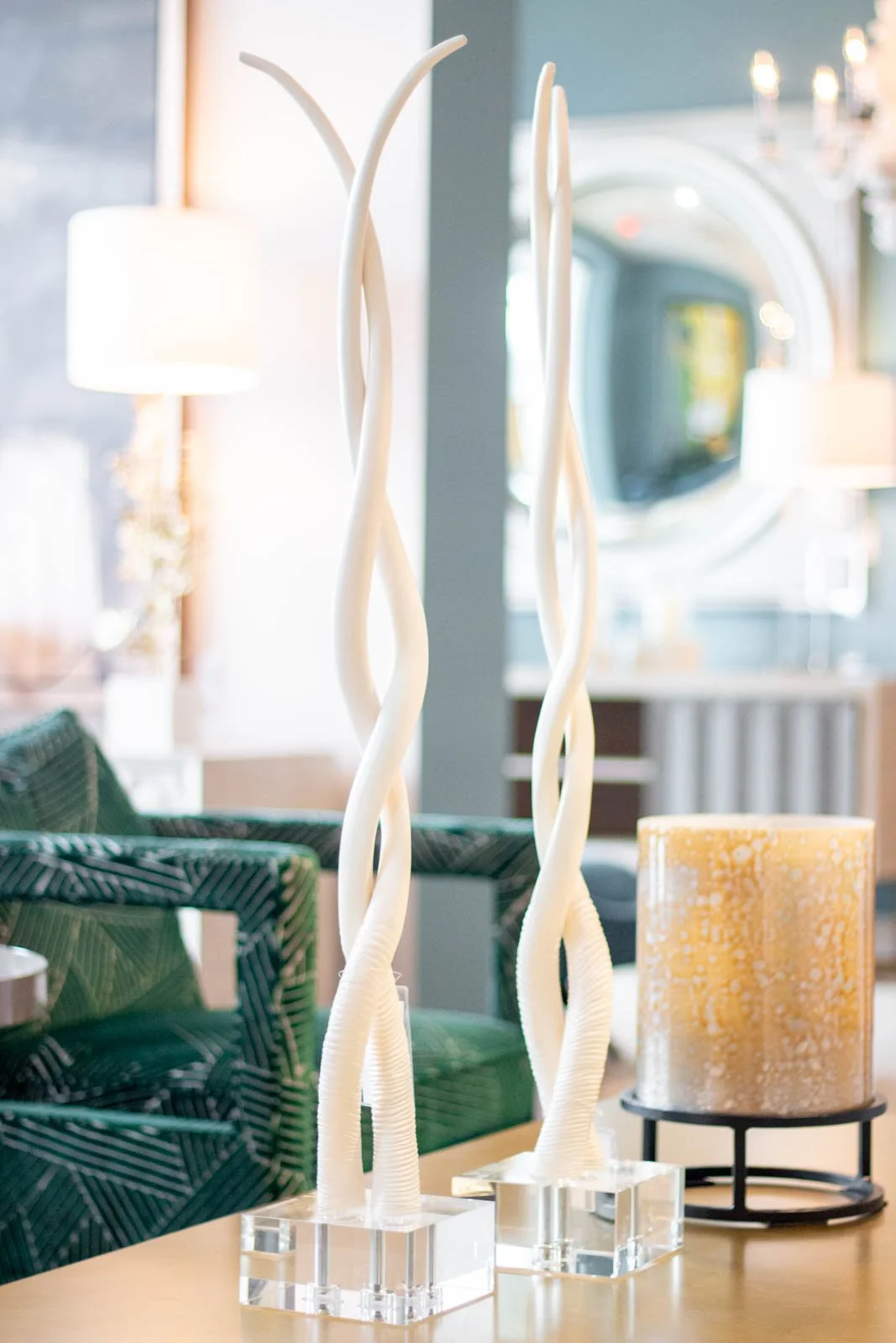 White windy statues in a light and airy showroom with a mirror, art, lamp and chandelier