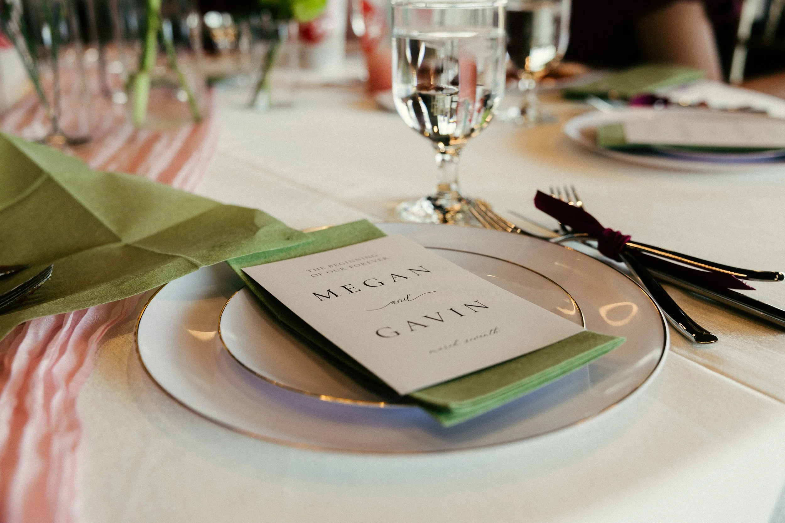 White plate with a green napkin placed on top followed by a card that says Megan and Gavin.