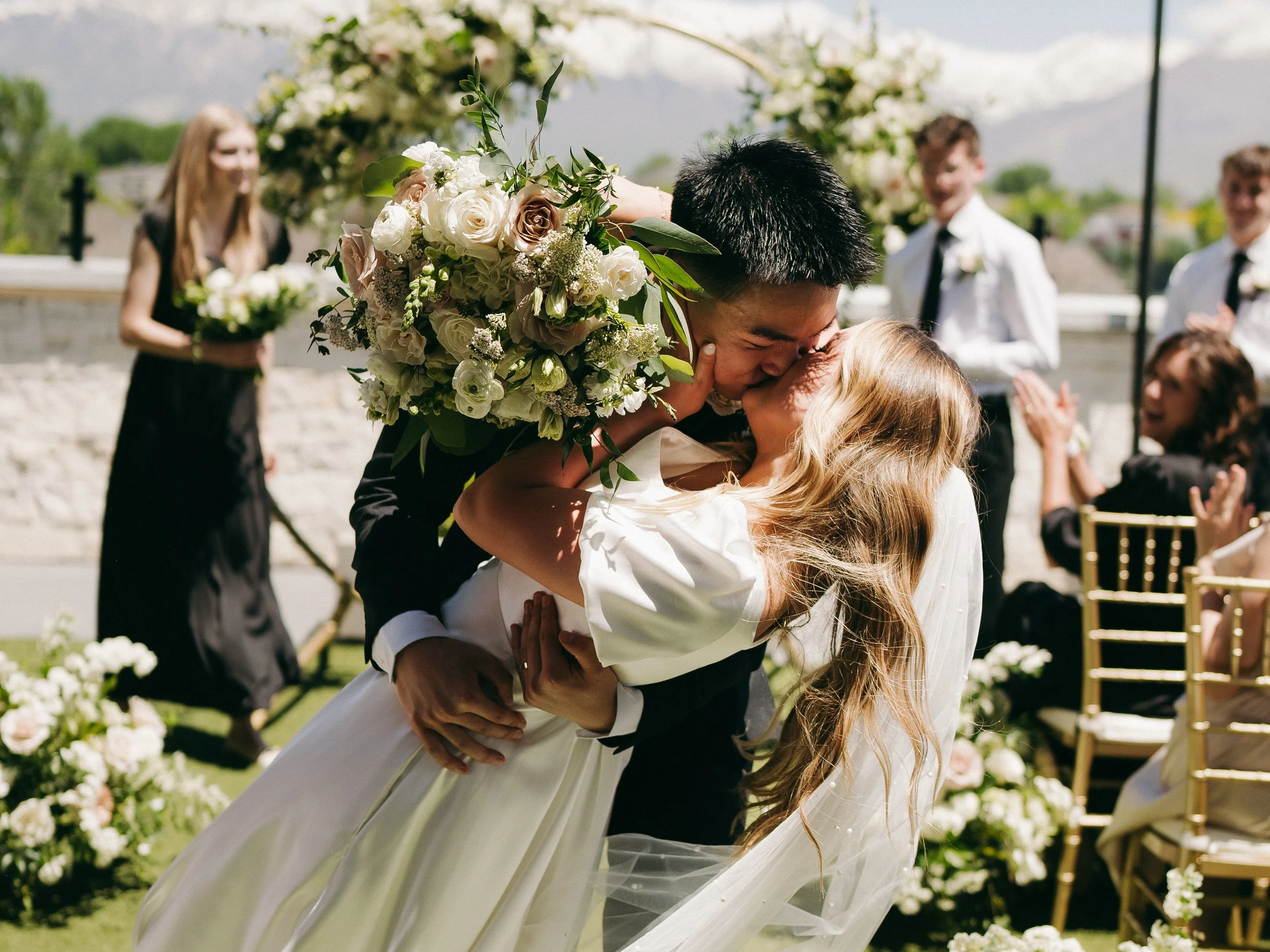 Groom dips the bride in the courtyard and they kiss.