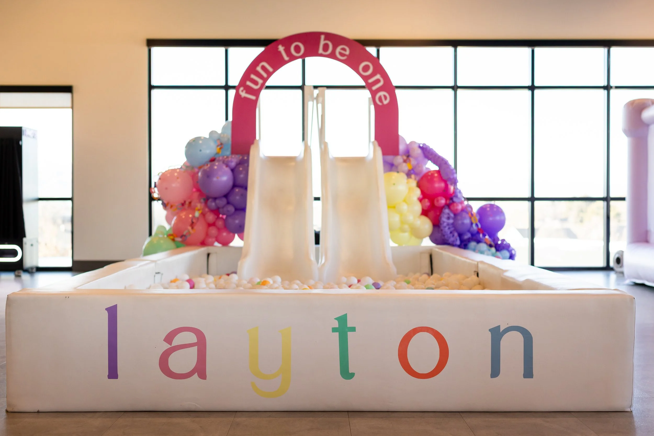 Personalized white ball pit with slides directing into it.