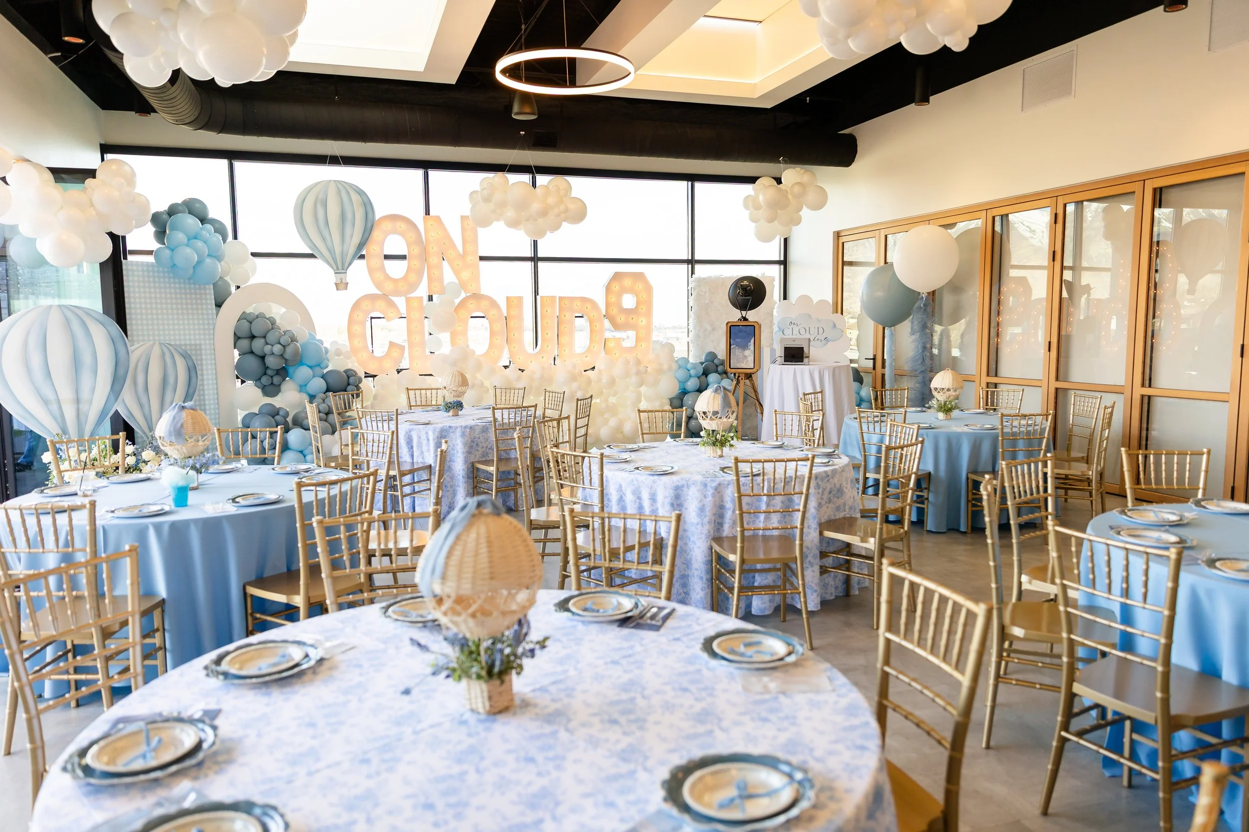 Large indoor venue space setup with blue and white baby shower decorations.