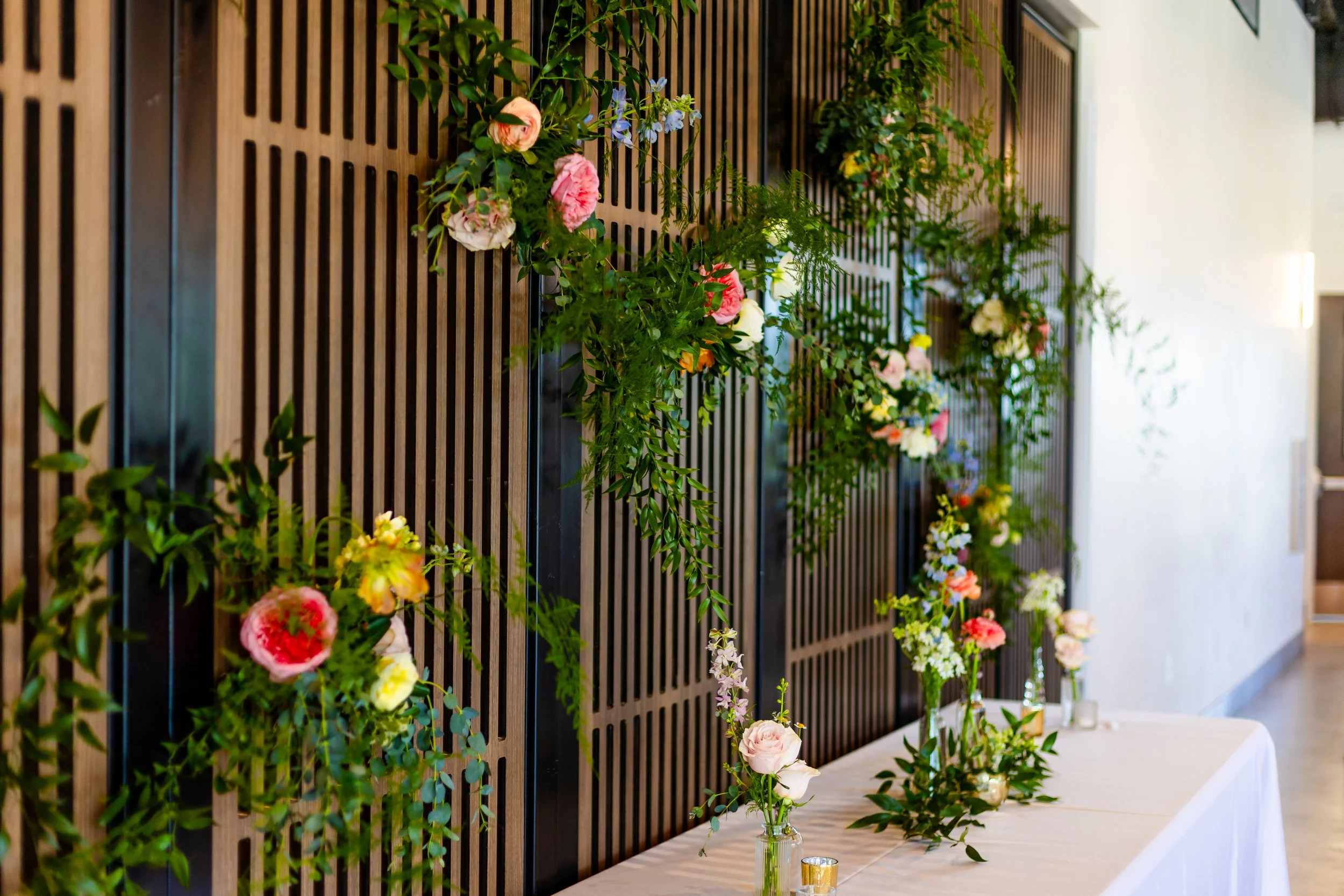 Brown and brown room divider decorated with flowers and greenery.