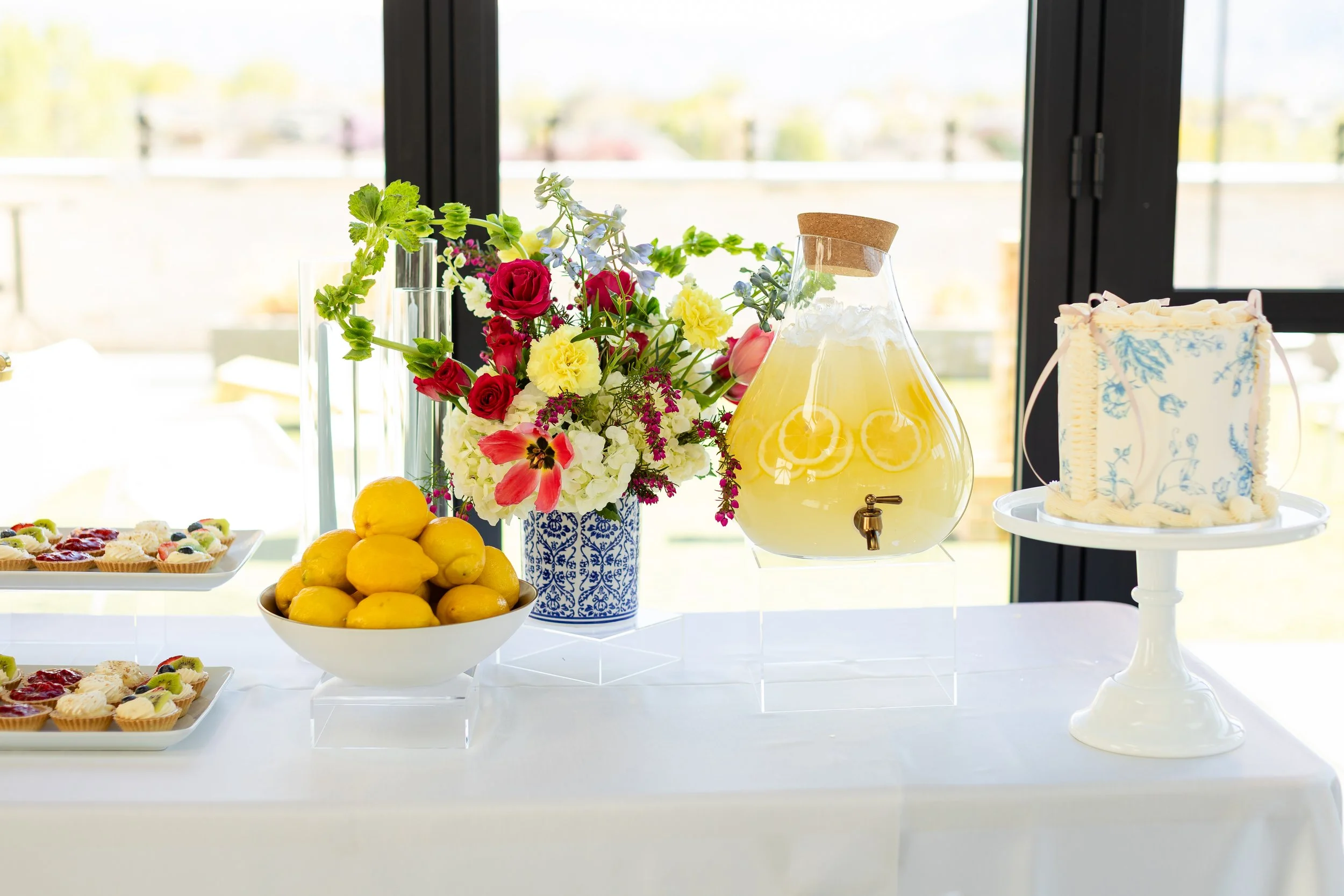 Event refreshment table with lemonade and single tiered cake.