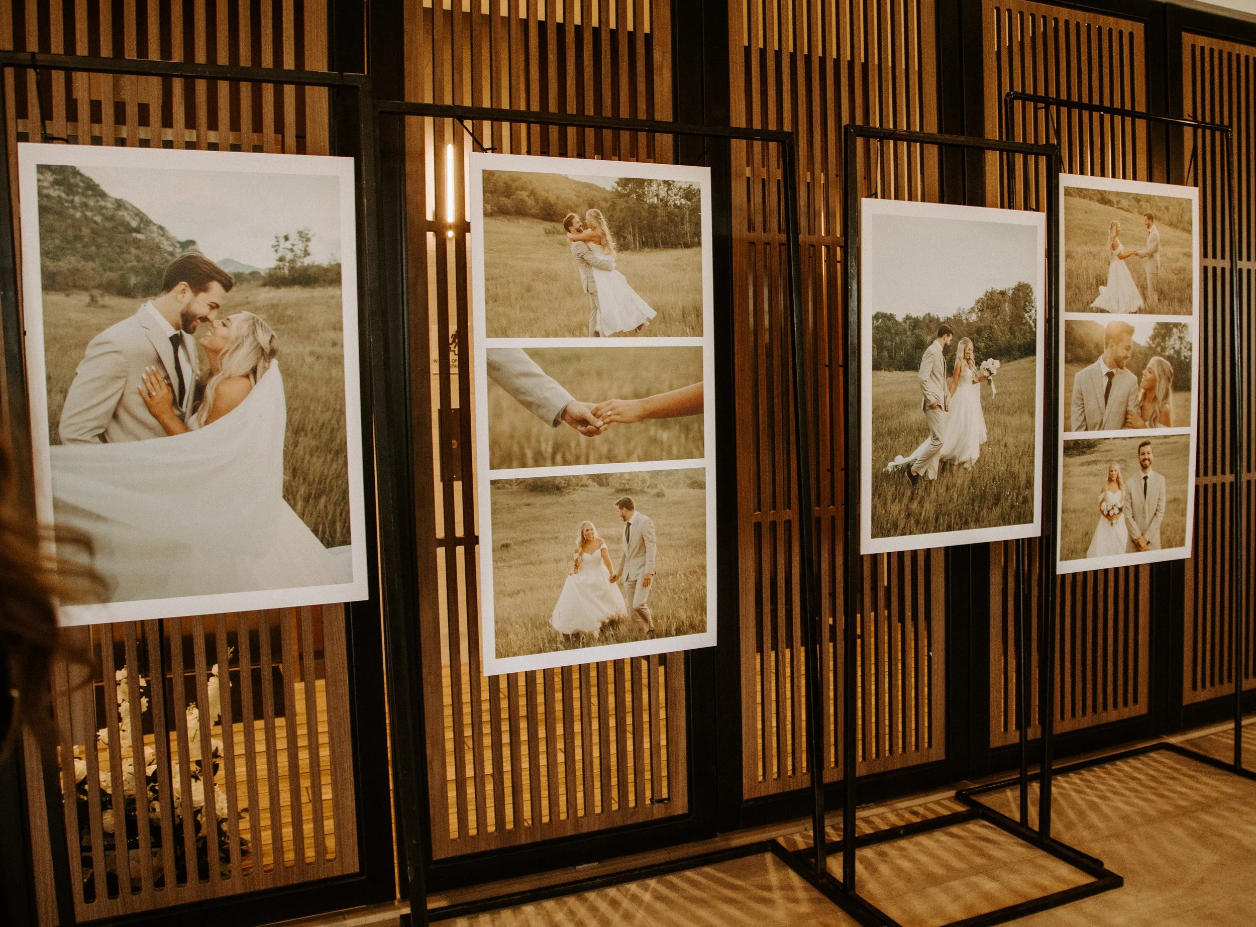 Bride and groom wedding photos printed and displayed on stands for the reception.