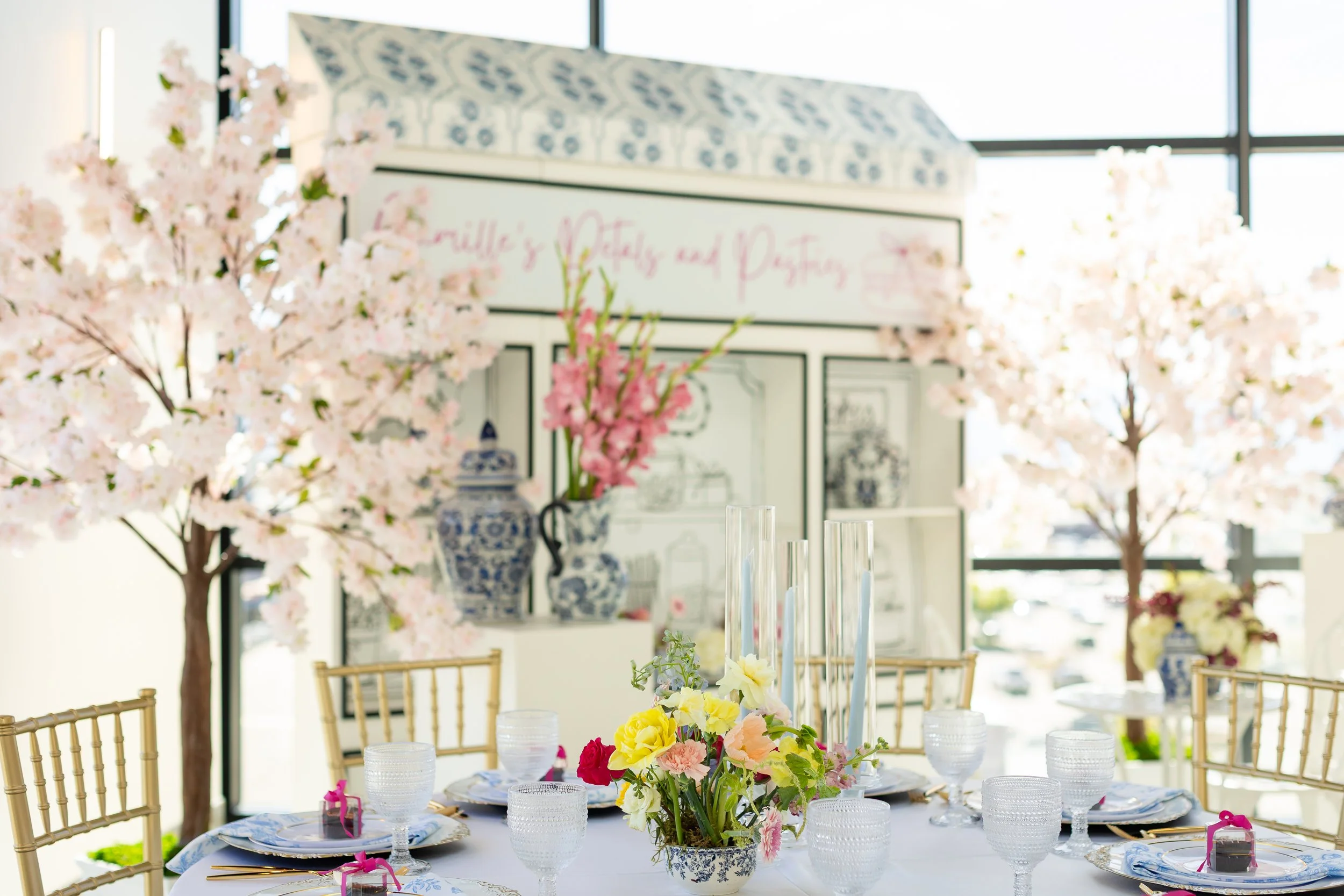 Bridal shower setup includes cherry blossom and potted flowers.