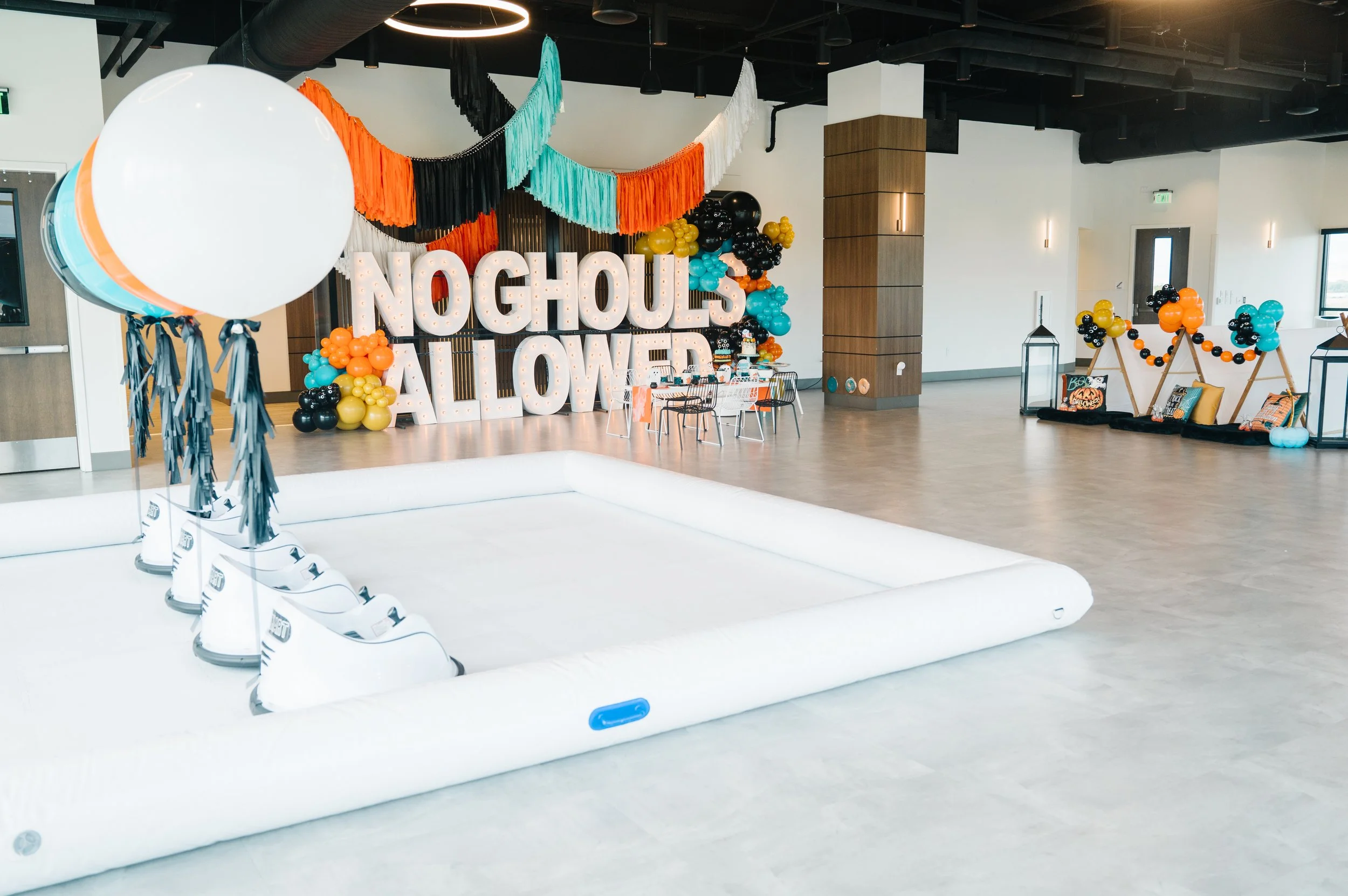 Marquee letters that say, "No ghouls allowed." Orange, black, blue, and white balloons and streamers.
