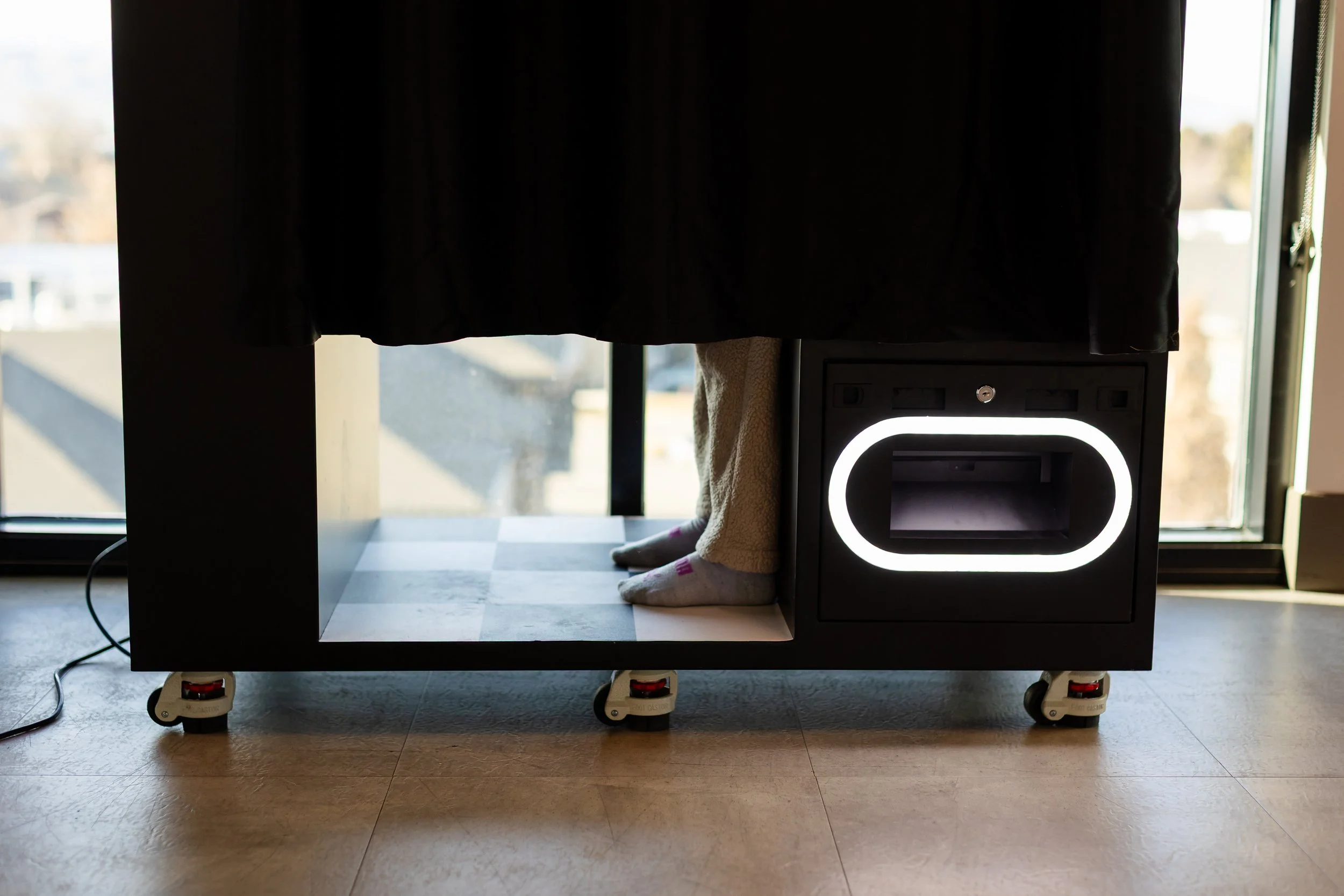 A person's feet are showing on the photobooth floor while taking a photo.
