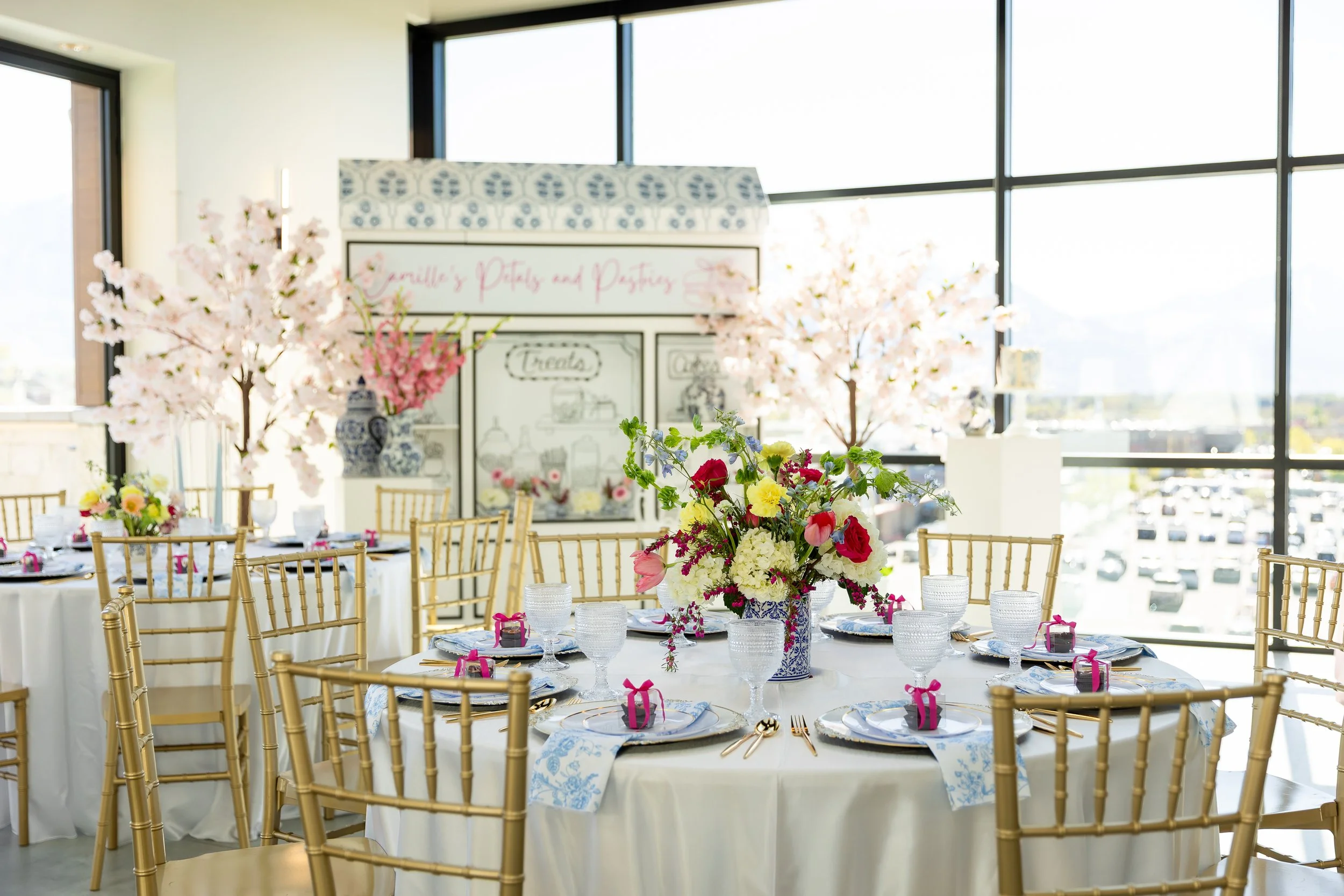 Spring bridal shower decorations that include faux blossoms, round tables, and floral centerpieces.