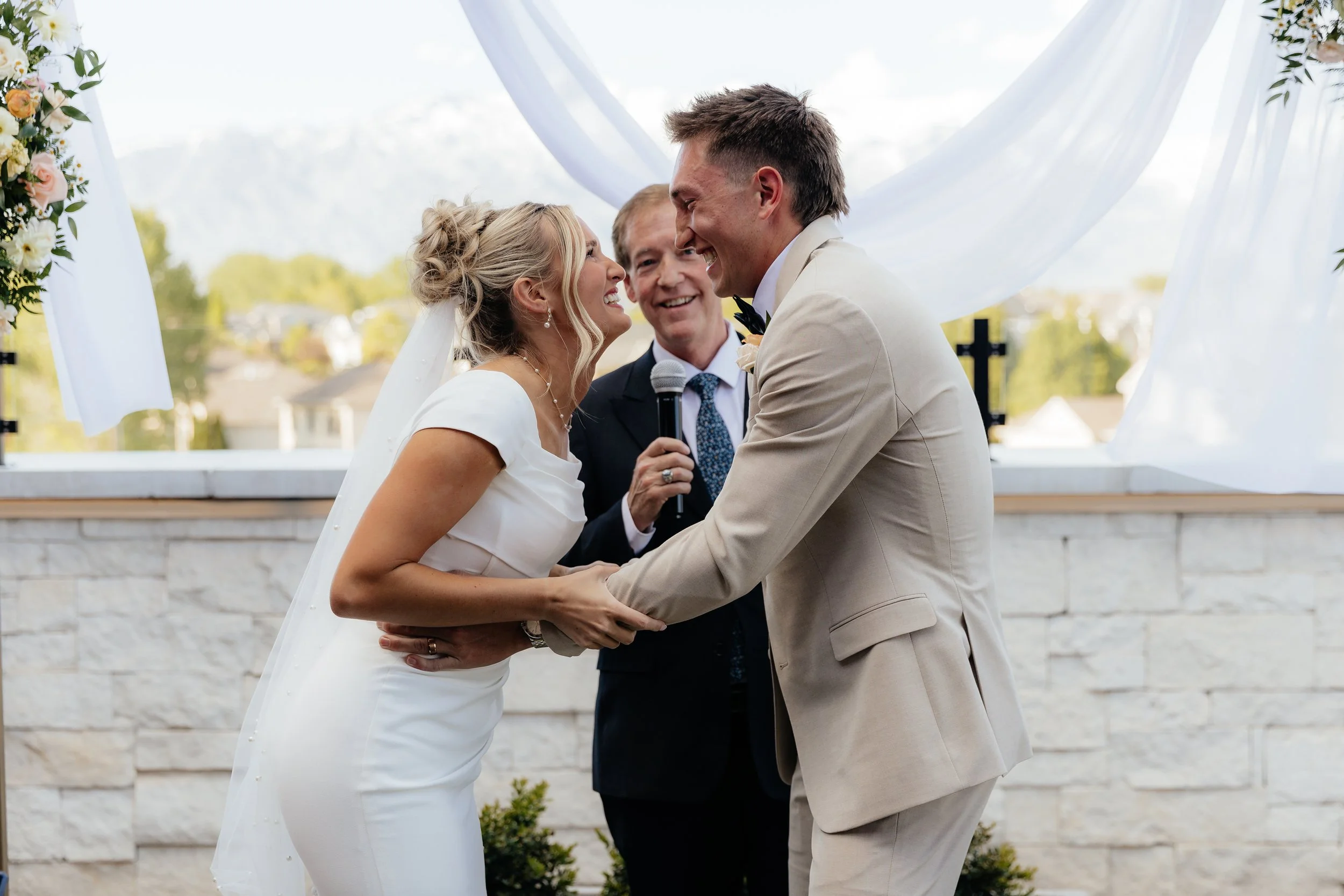 Bride and groom hold each other smiling.