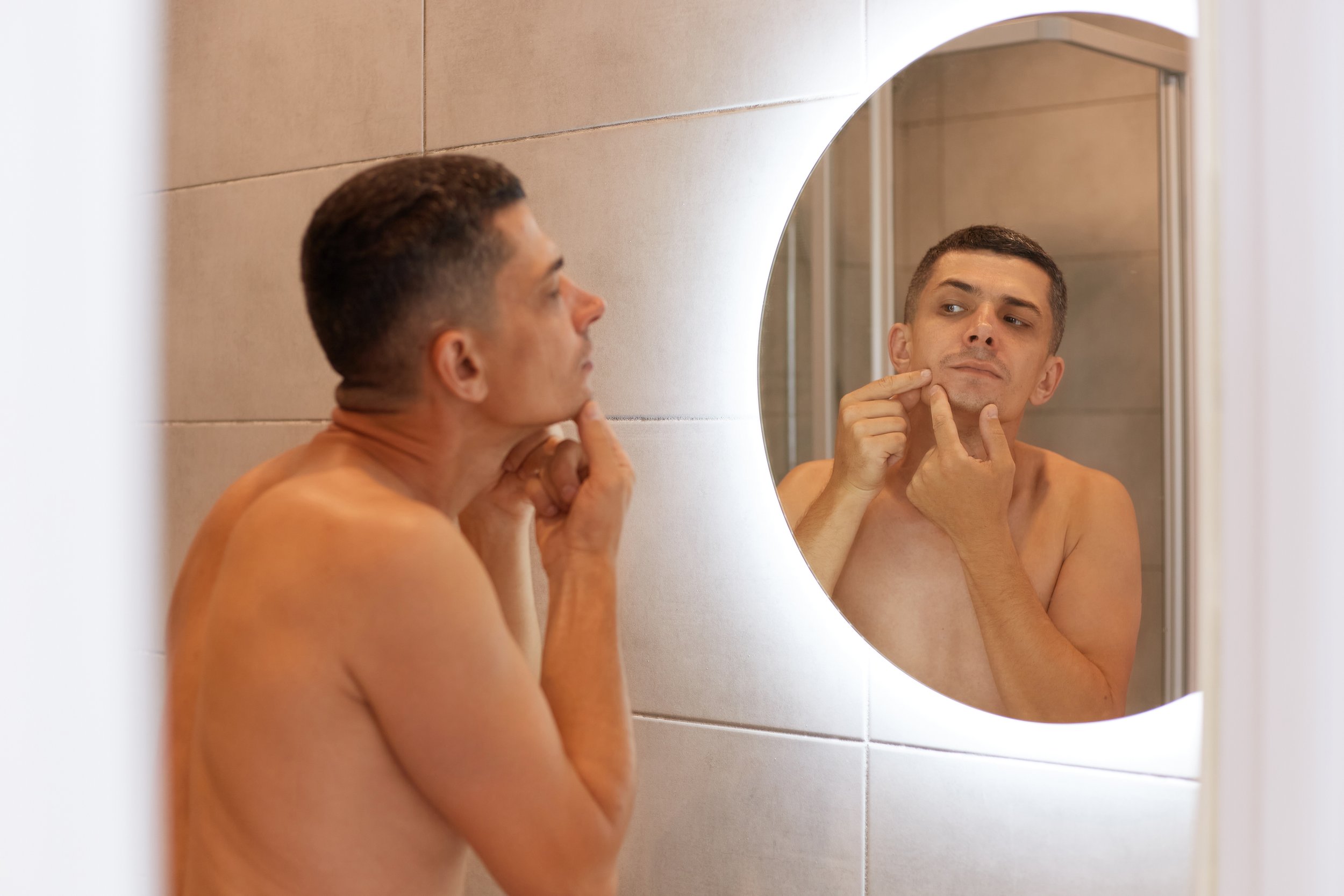 reflection-mirror-handsome-dark-haired-male-standing-with-naked-upper-body-looking-his-face-finds-pimple-having-skin-problems-morning-hygiene-procedures.jpg