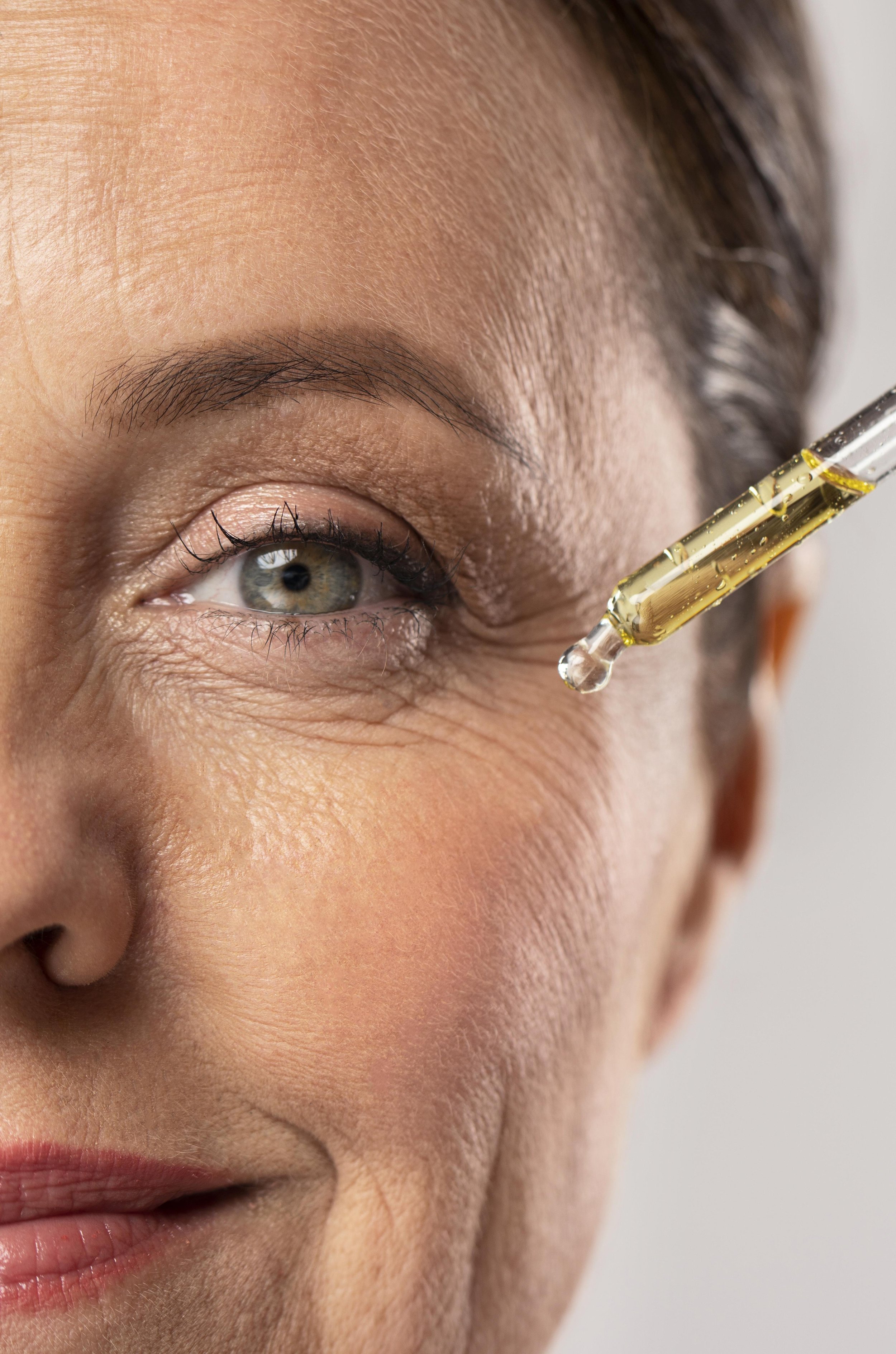 smiley-elder-woman-using-serum-her-eye-wrinkles.jpg