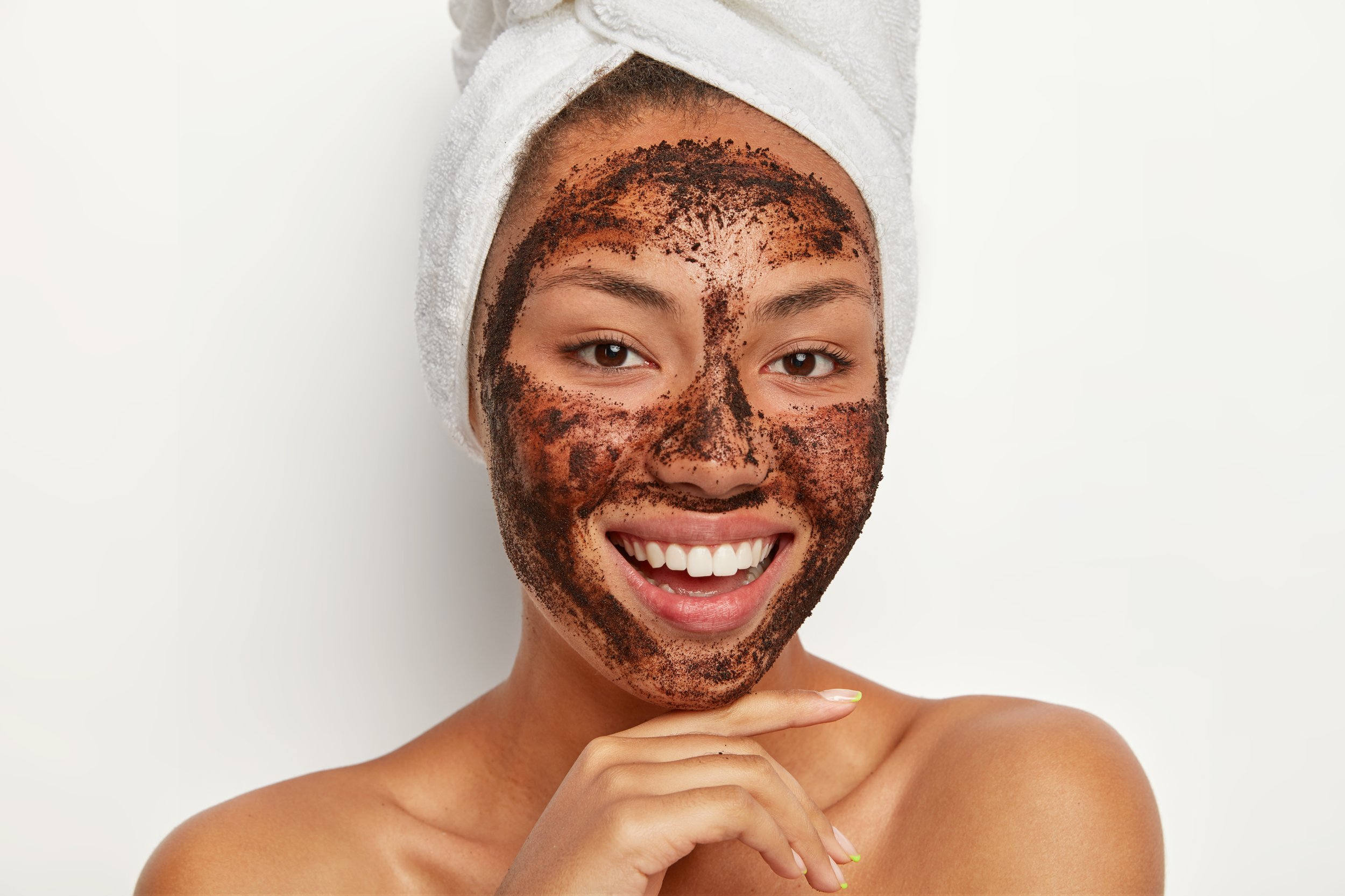 close-up-portrait-happy-afro-woman-touches-chin-gently-smiles-broadly-shows-white-teeth-cleans-face-applies-coffee-scrub-mask-wears-wrapped-towel-wet-hair-after-taking-bath-skin-care (1).jpg