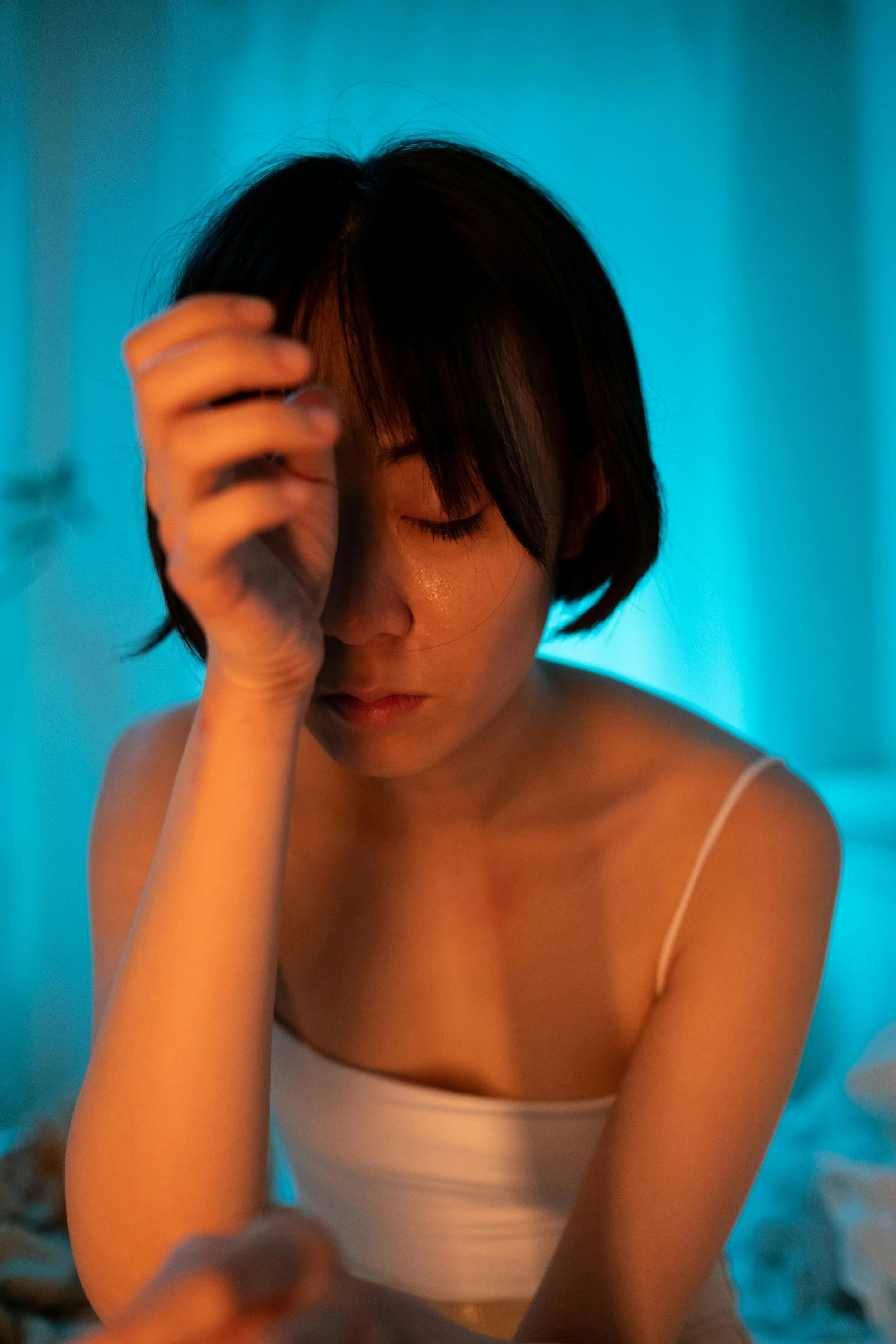 A stressed woman with her forehead resting on her arm.