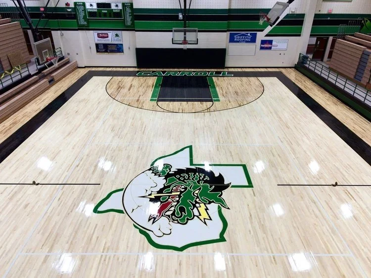 Basketball court with "Carroll" and a dragon logo.