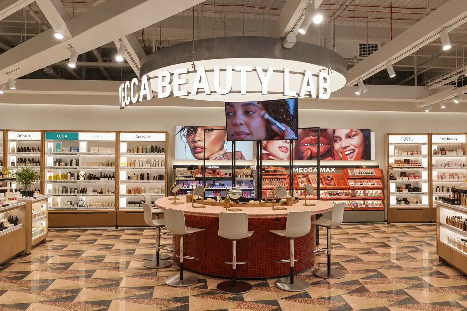 The Mecca Beauty Lab counter with tall stools, surrounded by shelves of skincare and makeup brands at Mecca Miranda.