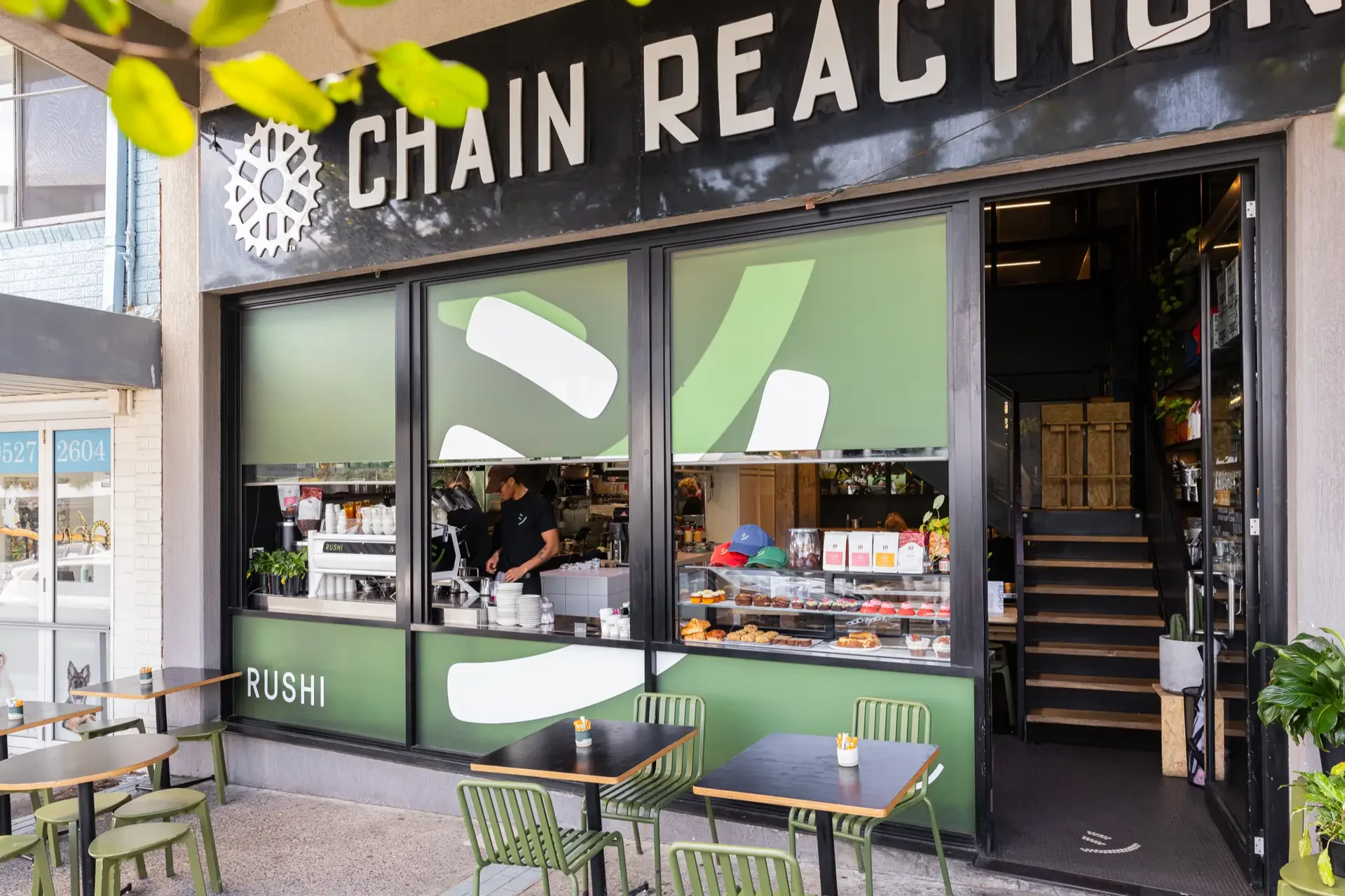 rushi-cafe-exterior-storefront-green-chairs.png