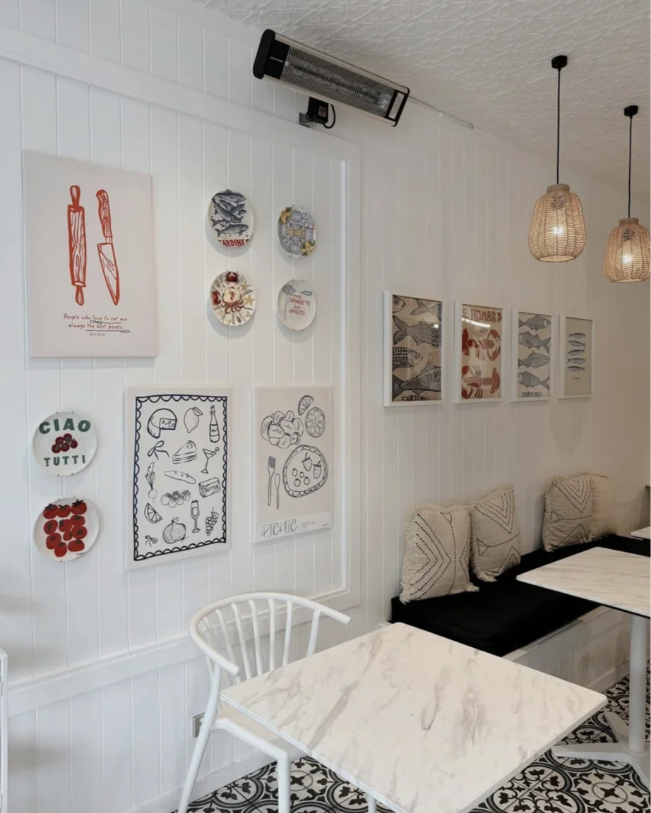 bianchinis-cafe-interior-gallery-wall-marble-tables.png