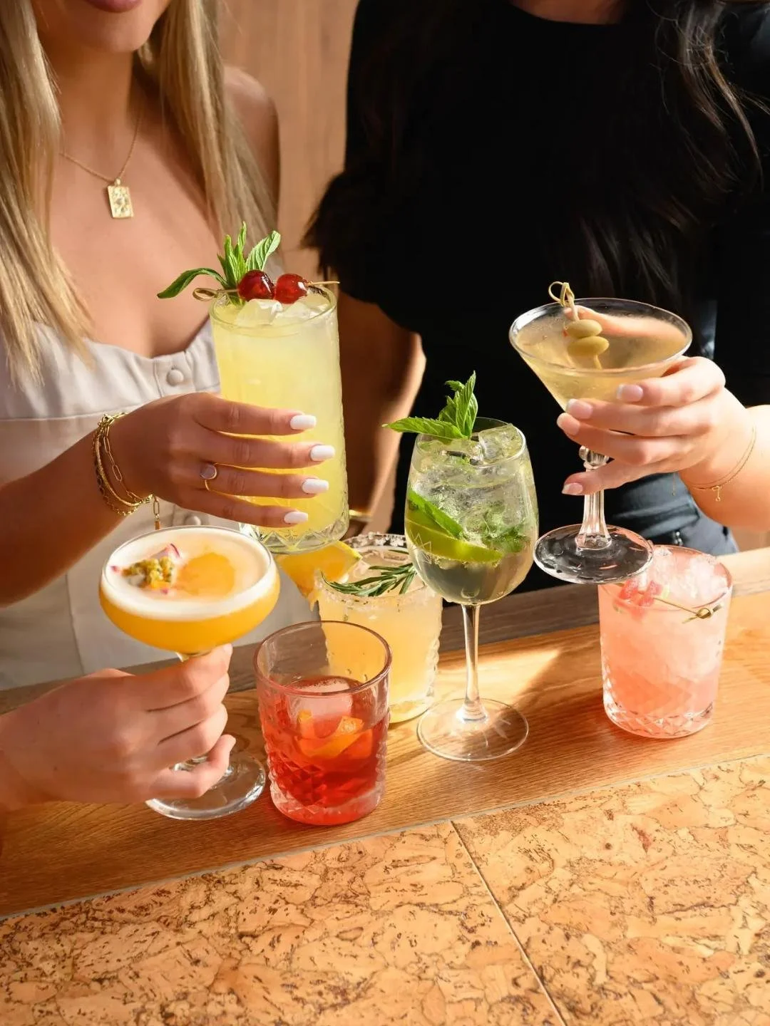 Friends holding a round of cocktails at Social House, Kirrawee