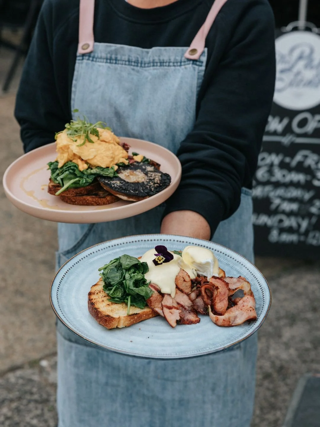 Waiter carrying breakfast plates outside Pan and Stone, Kirrawee