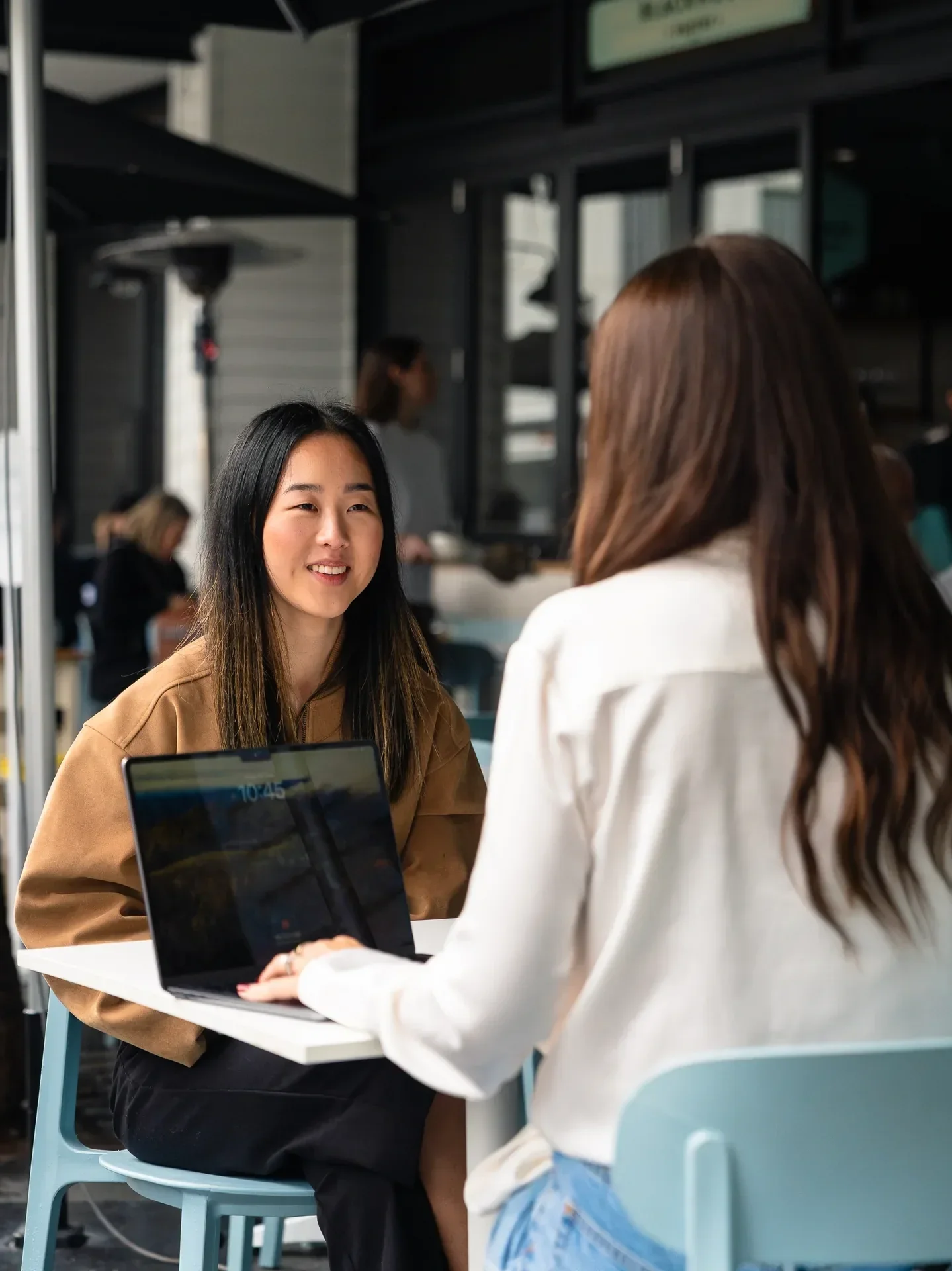 Two people discussing home loan options with a mortgage broker while looking at a laptop.