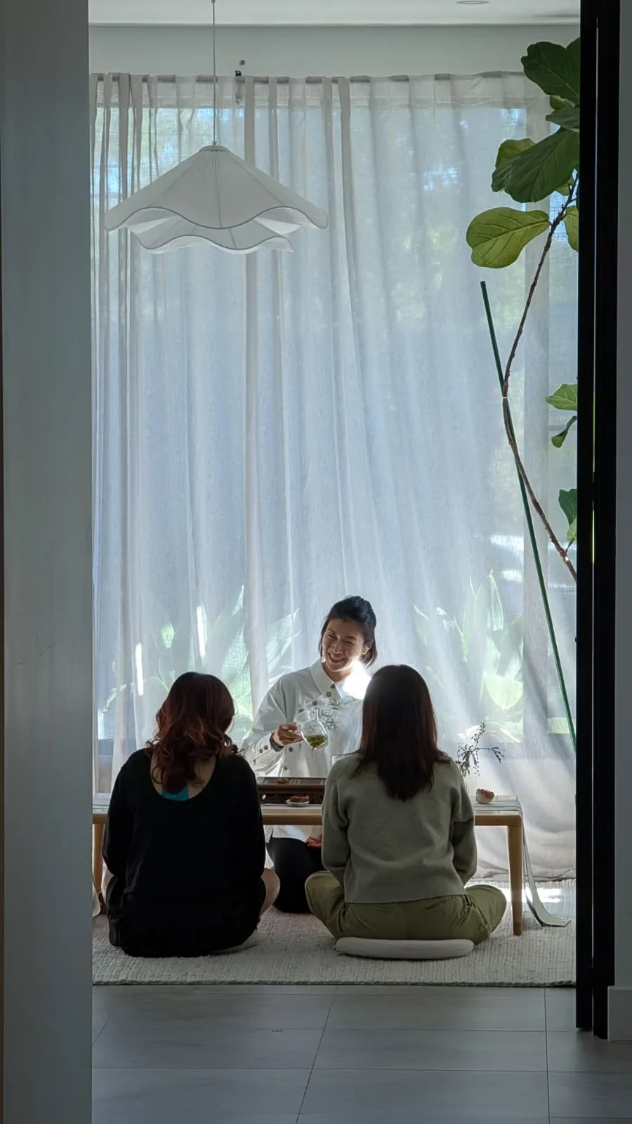Chinese tea ceremony class with guests seated around a table, learning traditional tea preparation and tasting techniques.