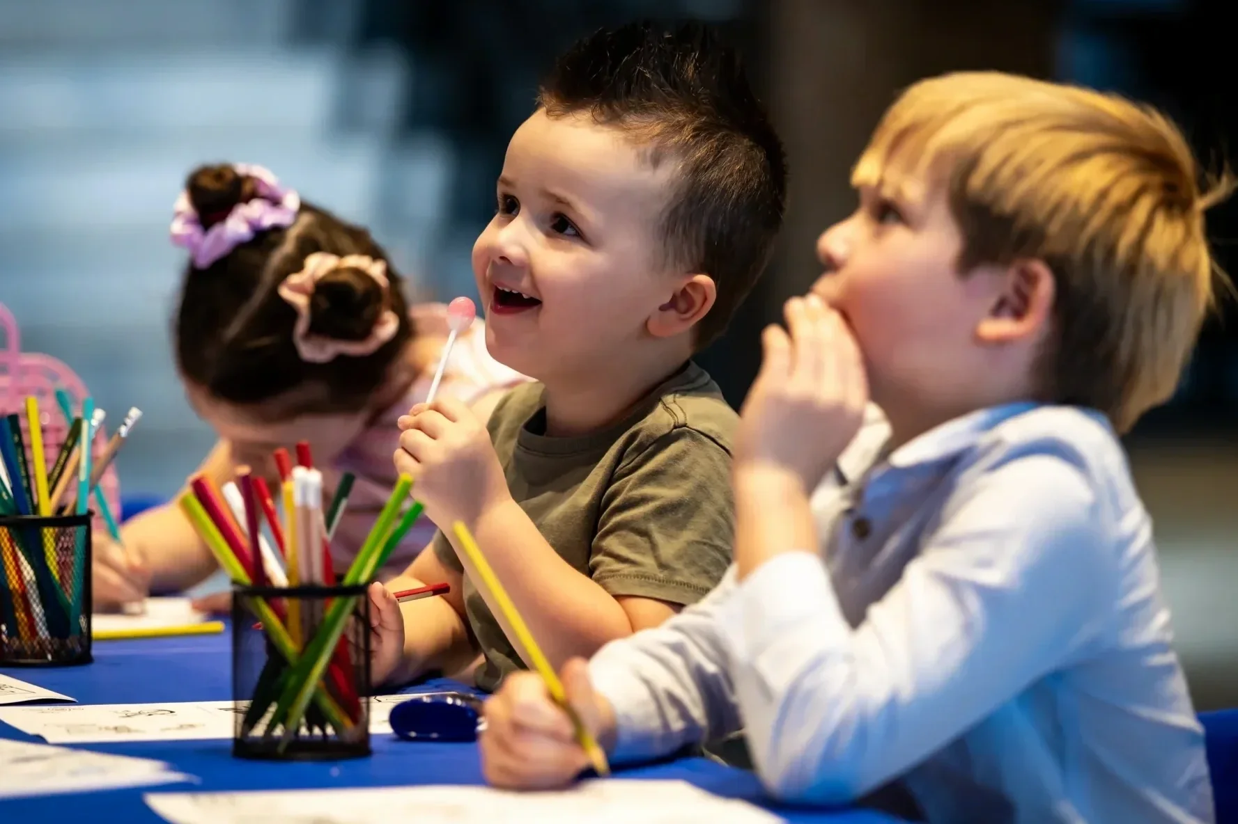 Kids drawing and colouring at a craft table during a play festival