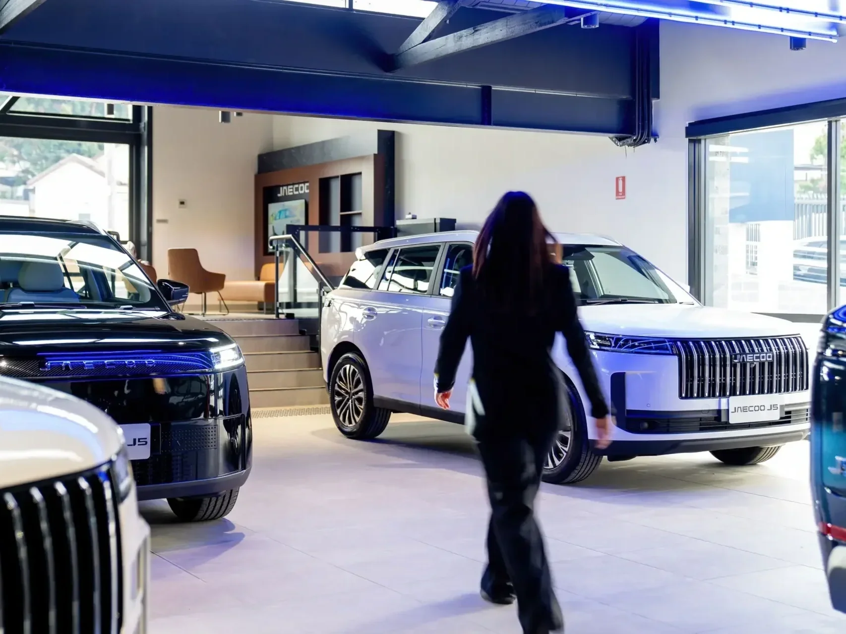 woman walking through the omoda jaecoo car dealership