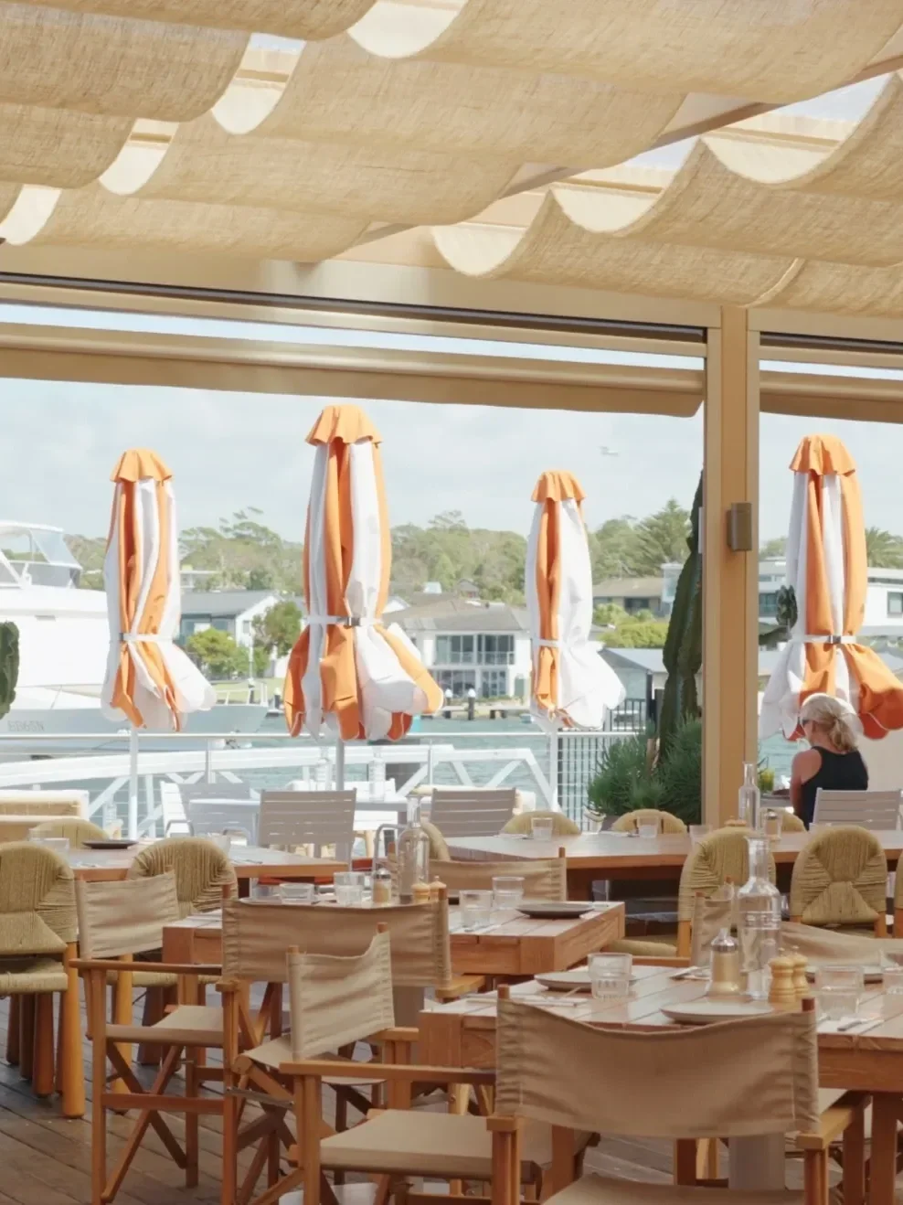 calico fold out chairs and folded umbrellas at an indoor outdoor seaside restaurant
