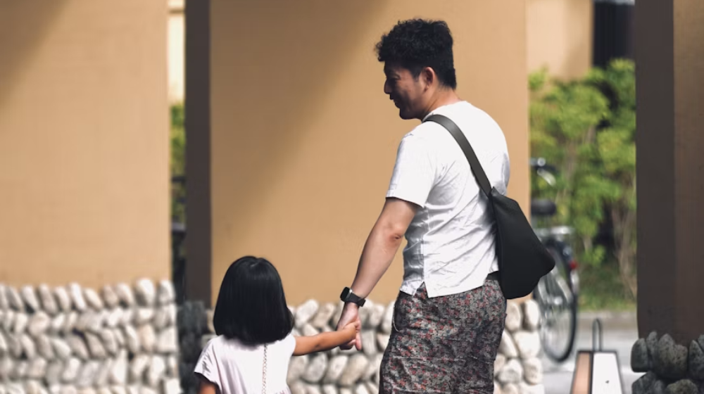 asian parent holding his daughter's hand
