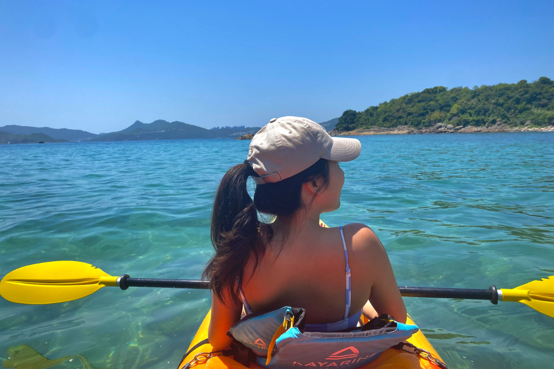 Ashley sitting on a kayak on the sea in Hong Kong.