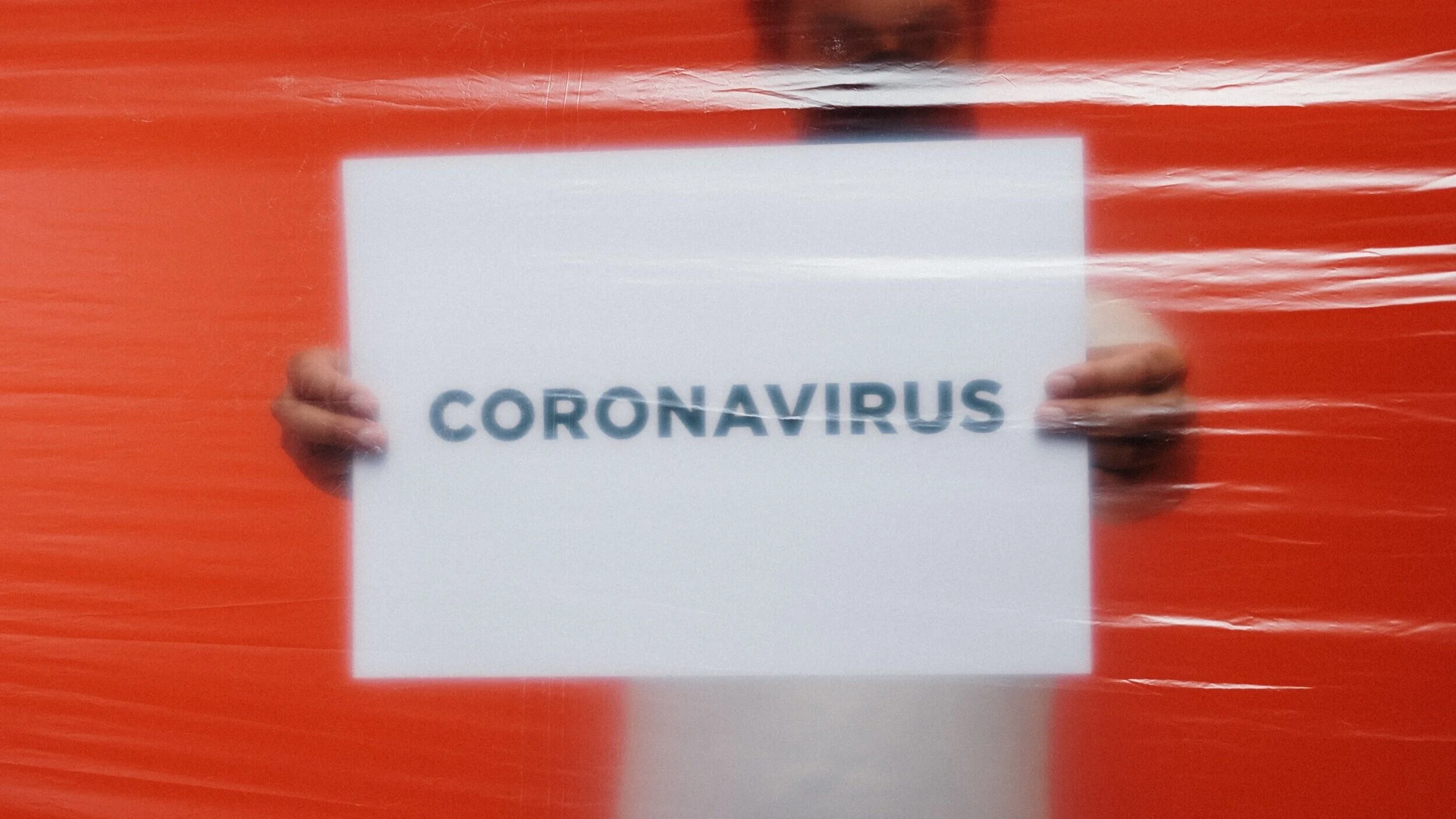 man-holding-a-coronavirus-sign-behind-a-plastic-3952196.jpg