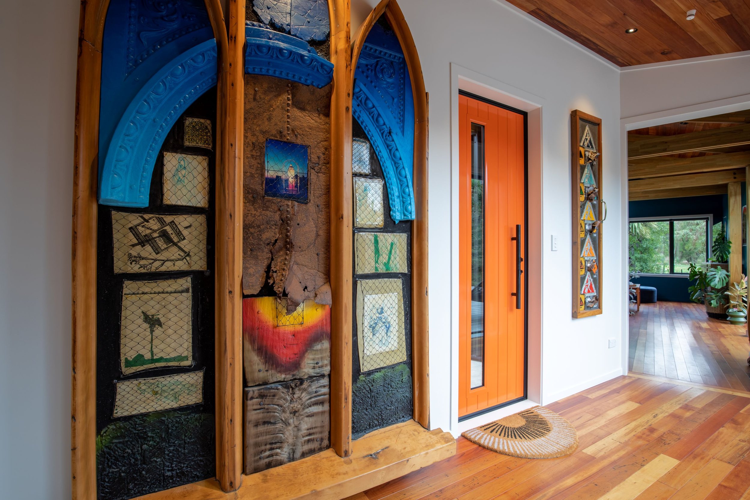 The orange front door alongside an artwork featuring an old church window that Hamish completed many years ago.jpg