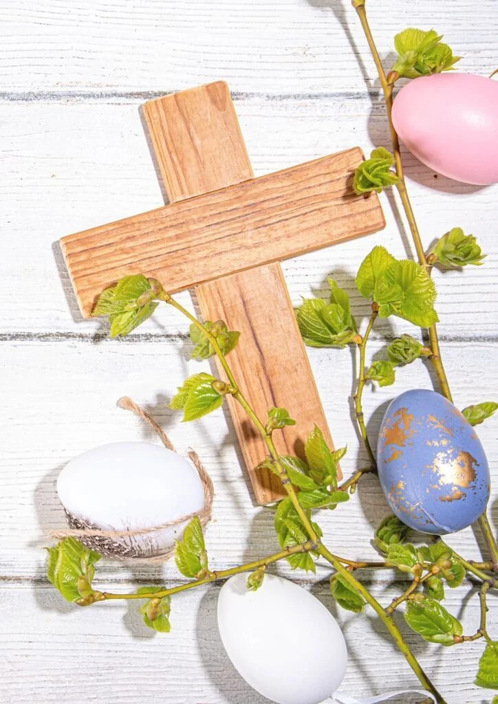 Various dishes including sliced brown bread with seeds, a bowl of fig slices, a bowl of green guacamole, and a platter of cooked eggplant topped with herbs and microgreens on a table.