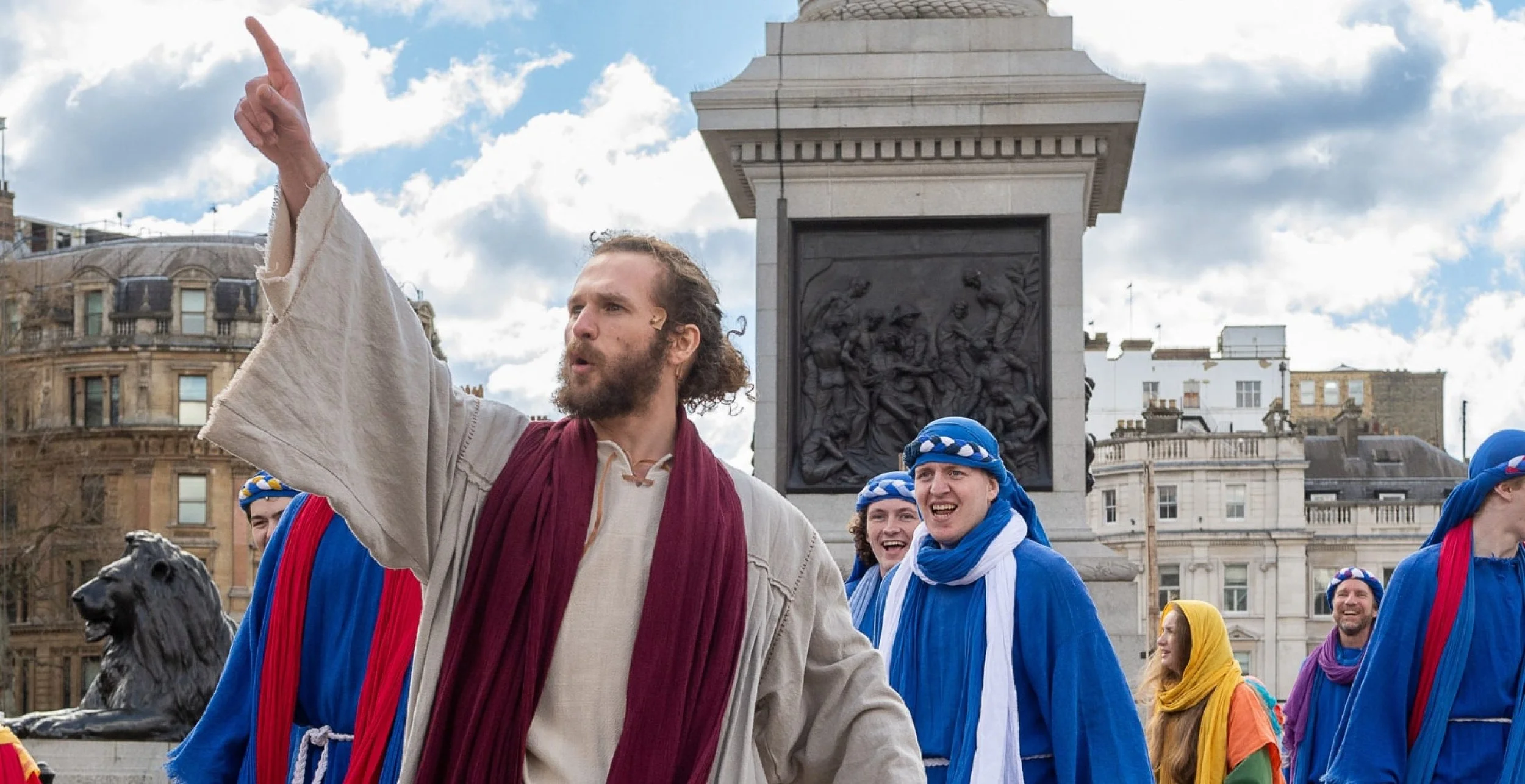 A crown of thorns made of intertwined, dry, thorny branches resting on dark soil.