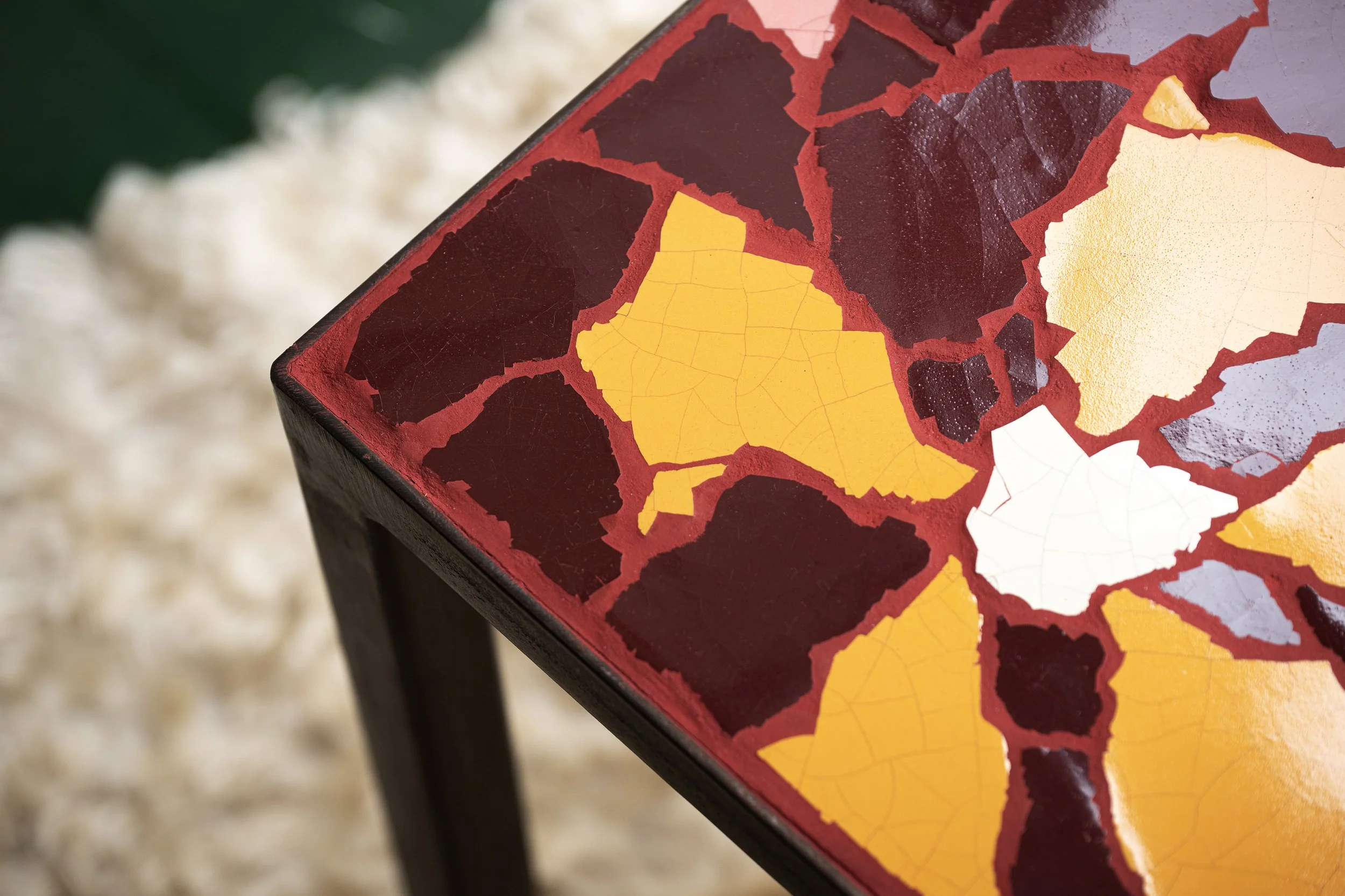 Close-up of a mosaic table with stained glass featuring a map of Bolivia, with different regions in yellow, white, and darker shades.