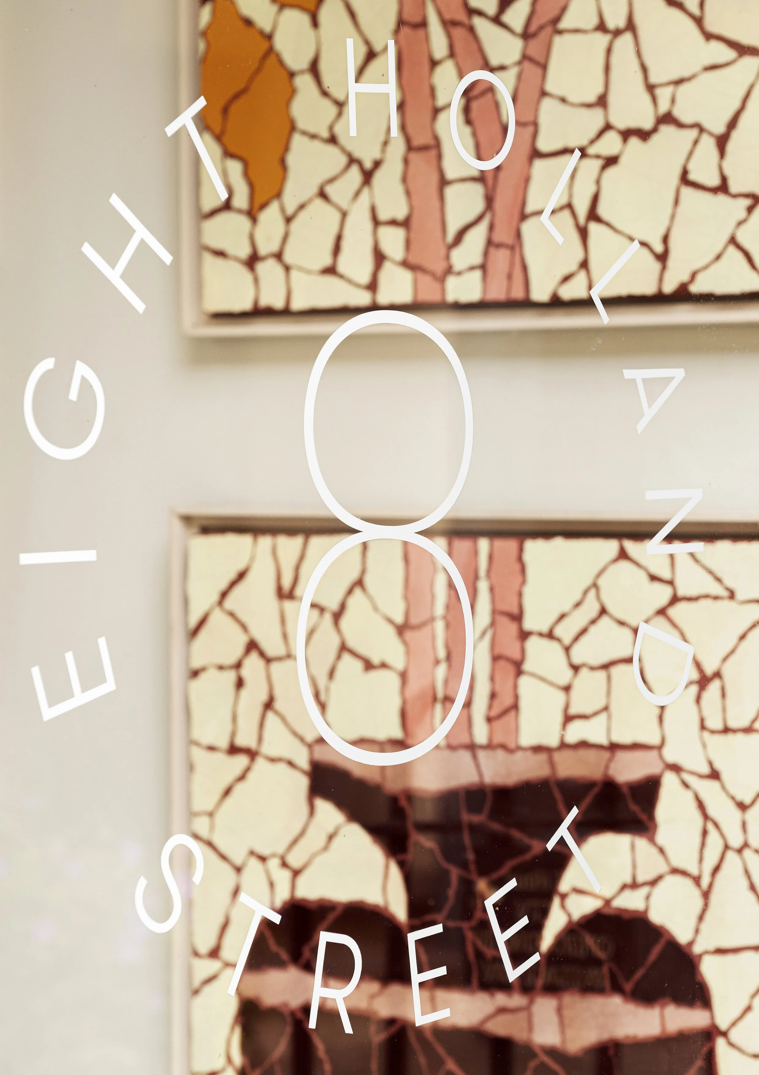 Close-up of a mosaic or cracked tile artwork with the words 'EIGHTH STREET' and the number '8' overlaid in white text.