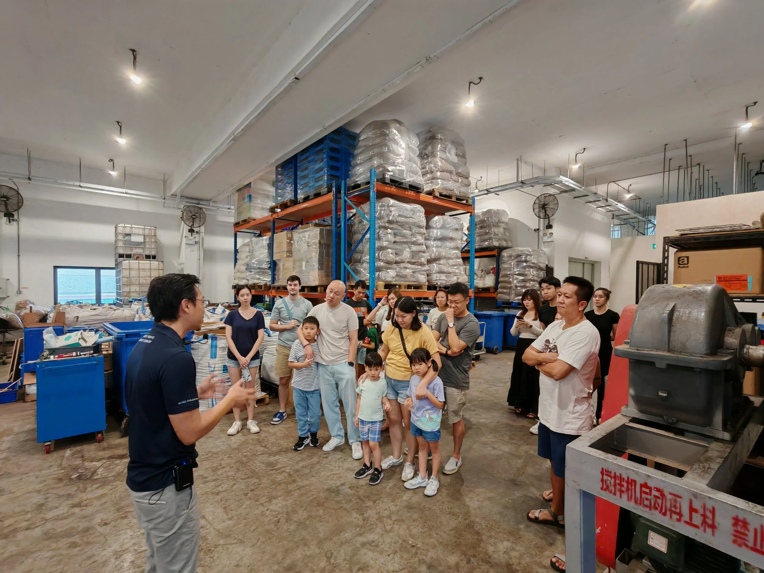 A group of site tour visitors participating and listening to Nathenial Phua, Ento Industries CEO explain during a site tour to Ento Industries's Facility