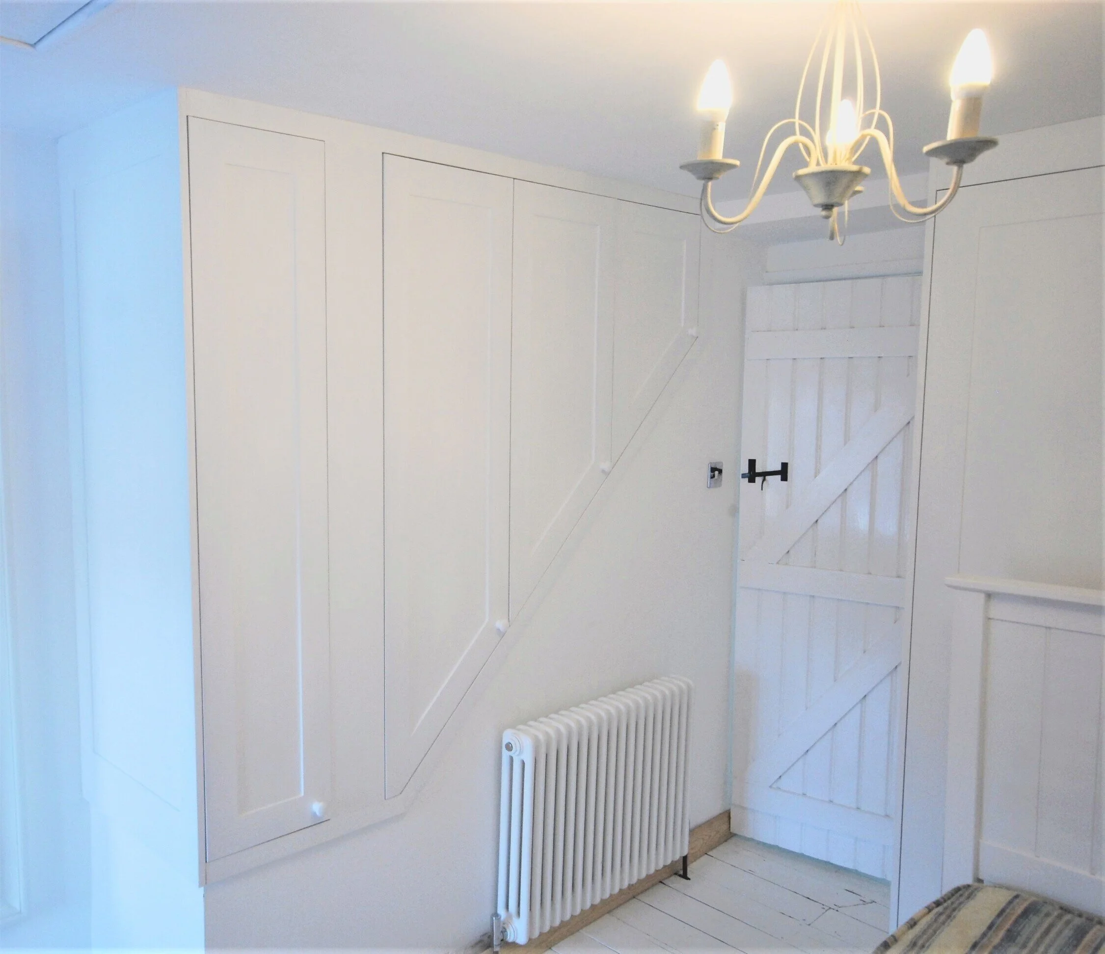 Bepsoke Angled wardrobe storage to go in an awkward space over the stairs in a cottage in Christchurch town