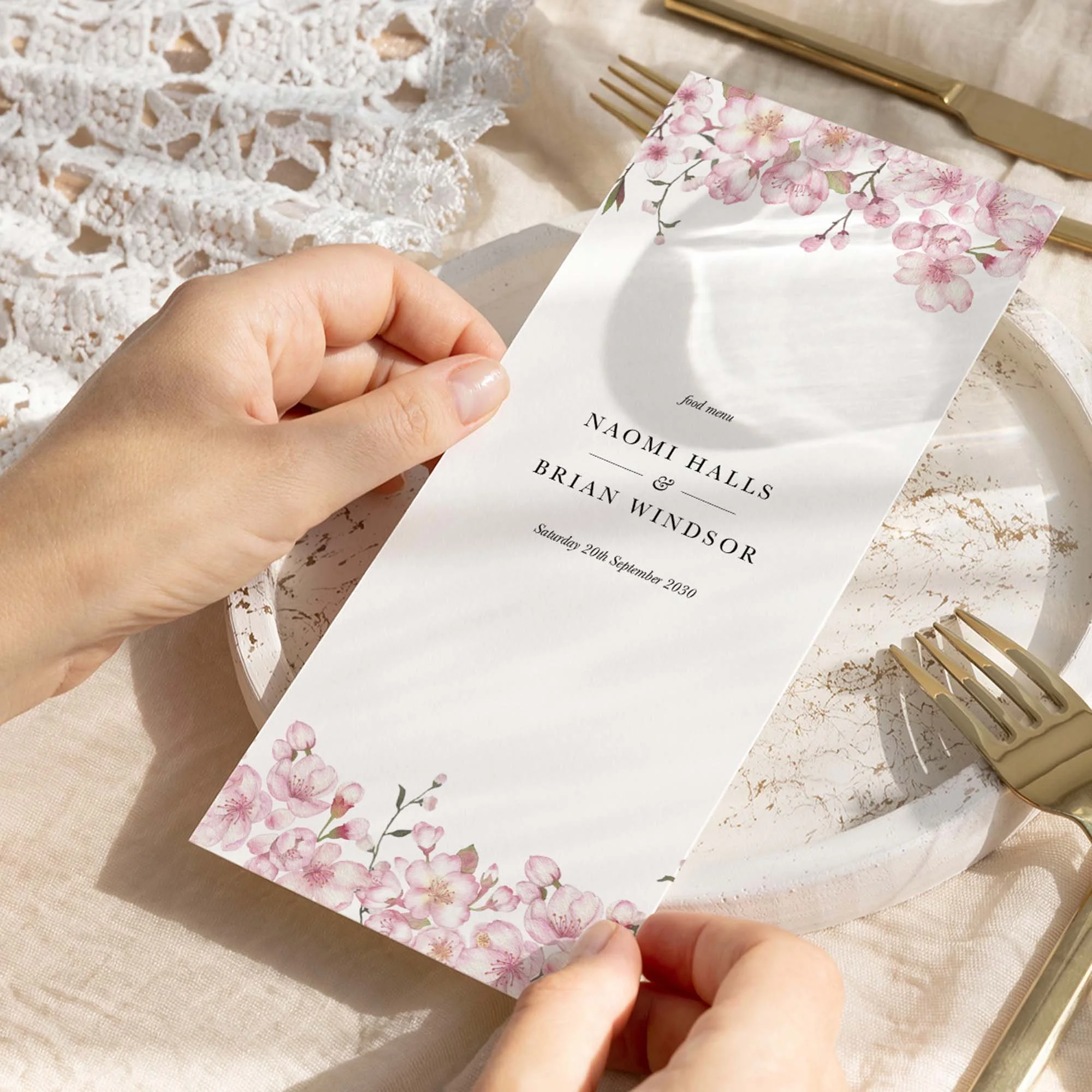 Hand holding Cherry Blossom wedding menu card showing size and printed design details