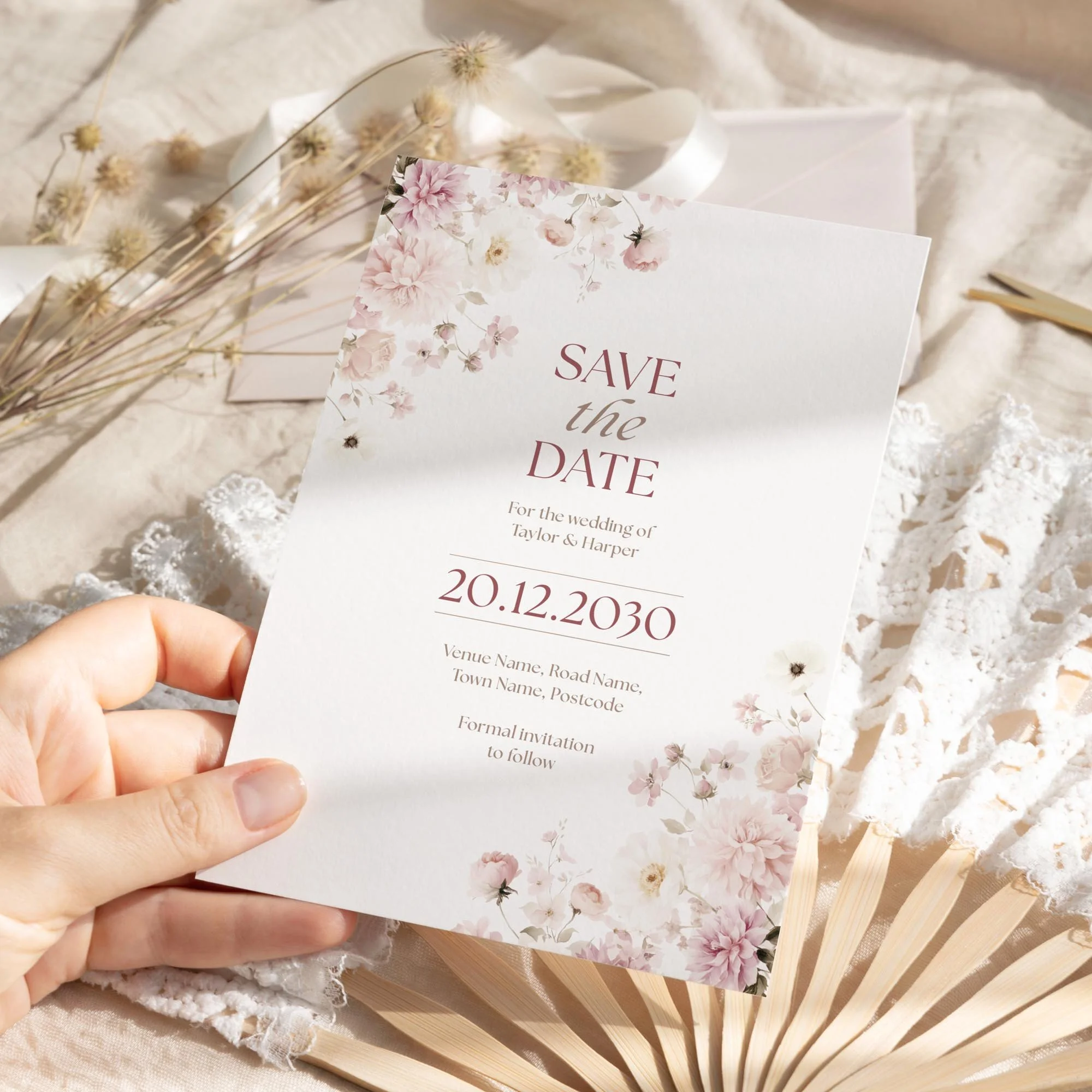 Person holding the Petal Save the Date with elegant floral design in blush tones.