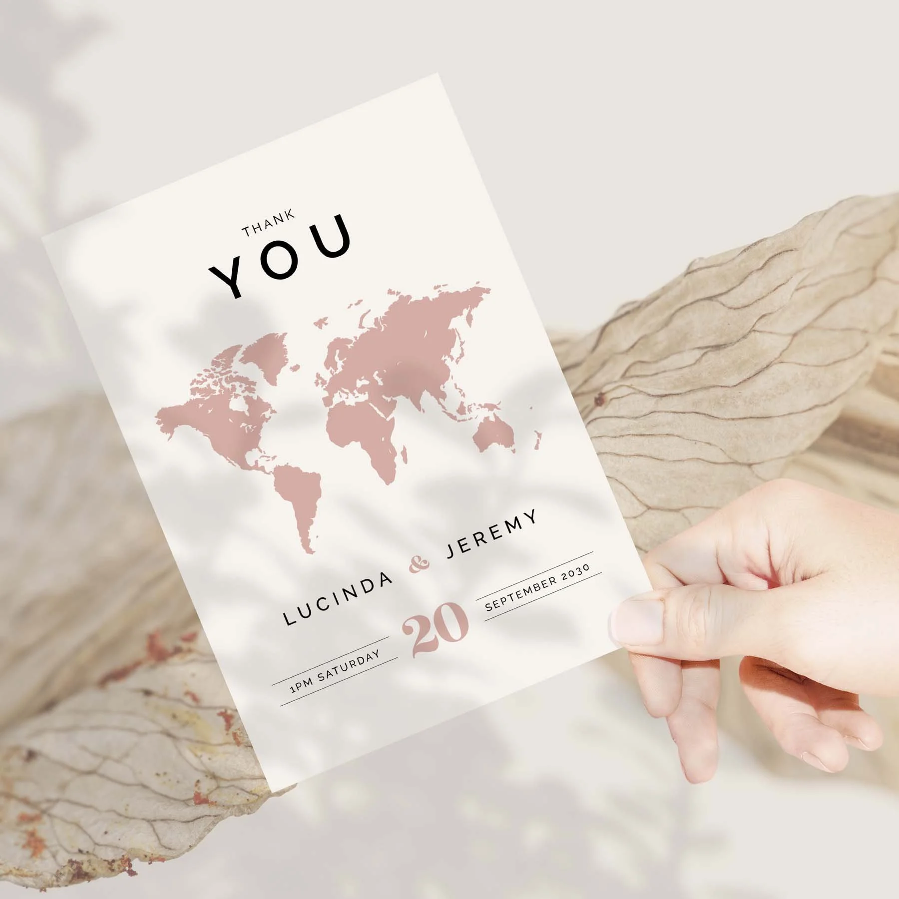 Hand holding a Travel Theme wedding thank you card